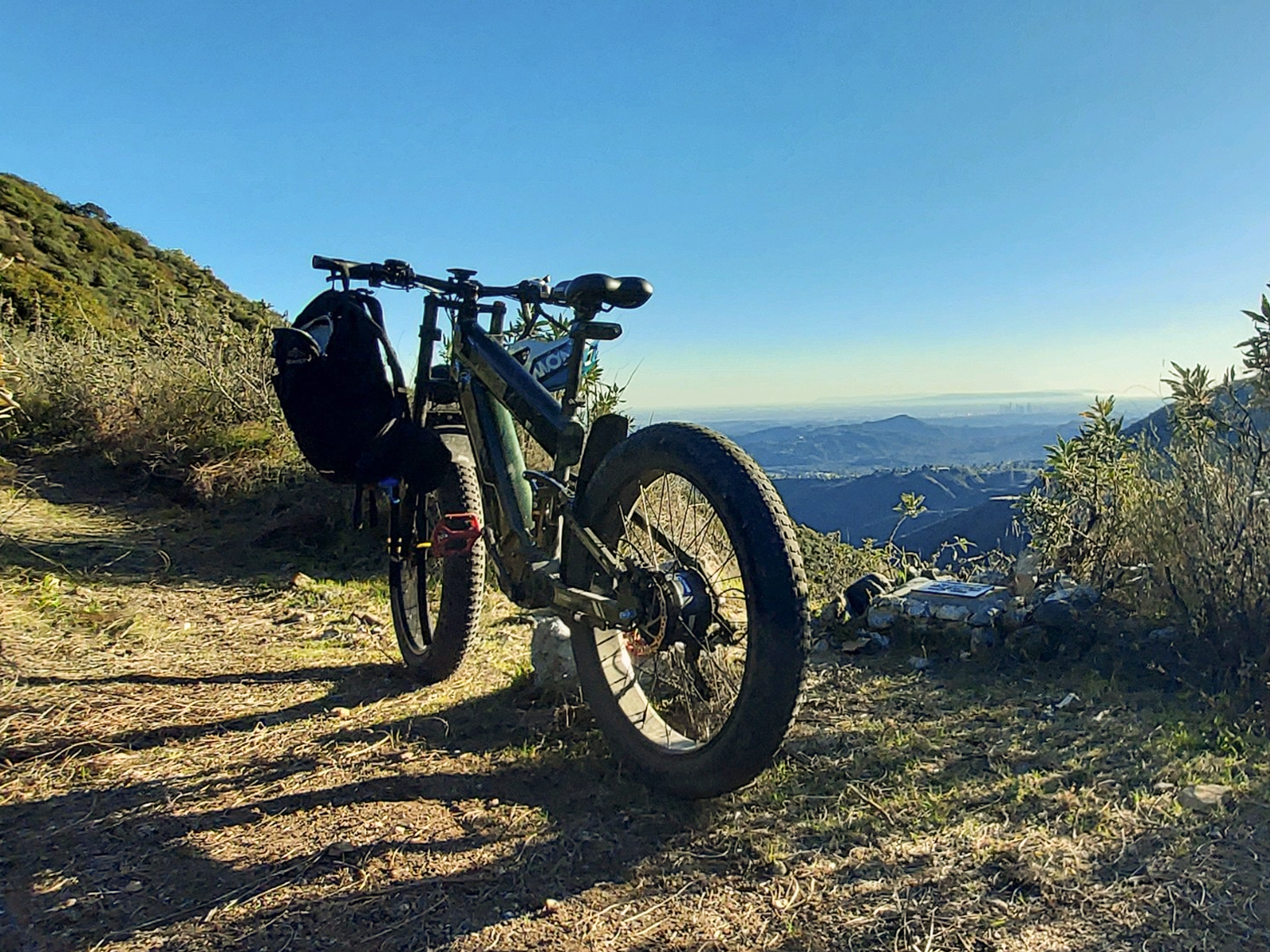 Black Freesky e-bike with rear rack on dirt trail
