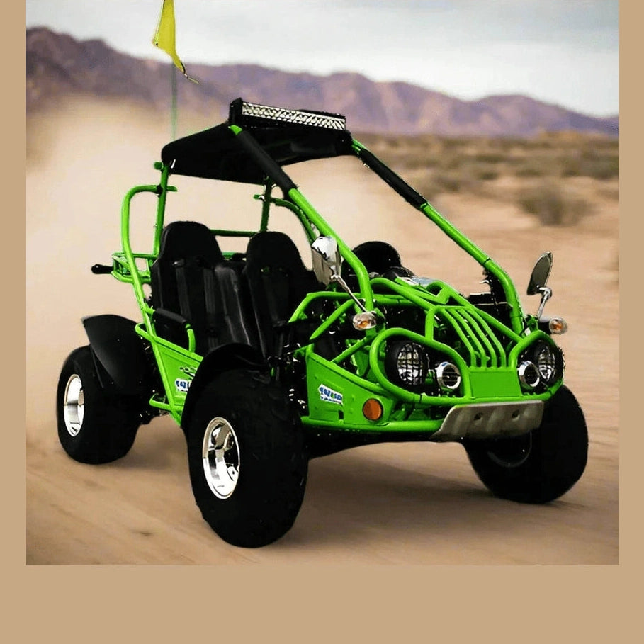 Green Trailmaster go kart in motion on dusty desert trail with mountains background