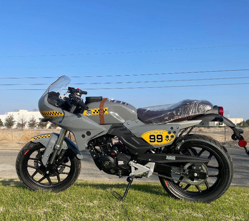 American lifan kp master motorcycle with yellow racing decals and windscreen parked on grass under blue sky