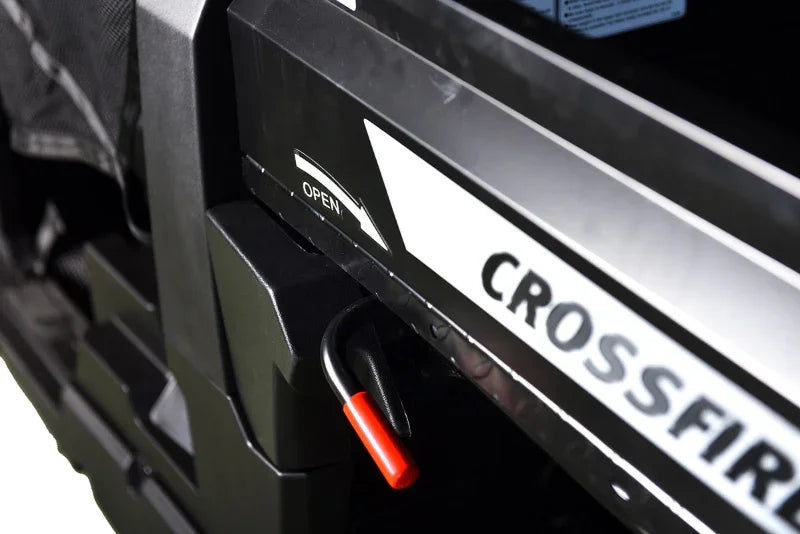 Utility vehicle dump bed latch with red handle and open arrow, Crossfire branding visible