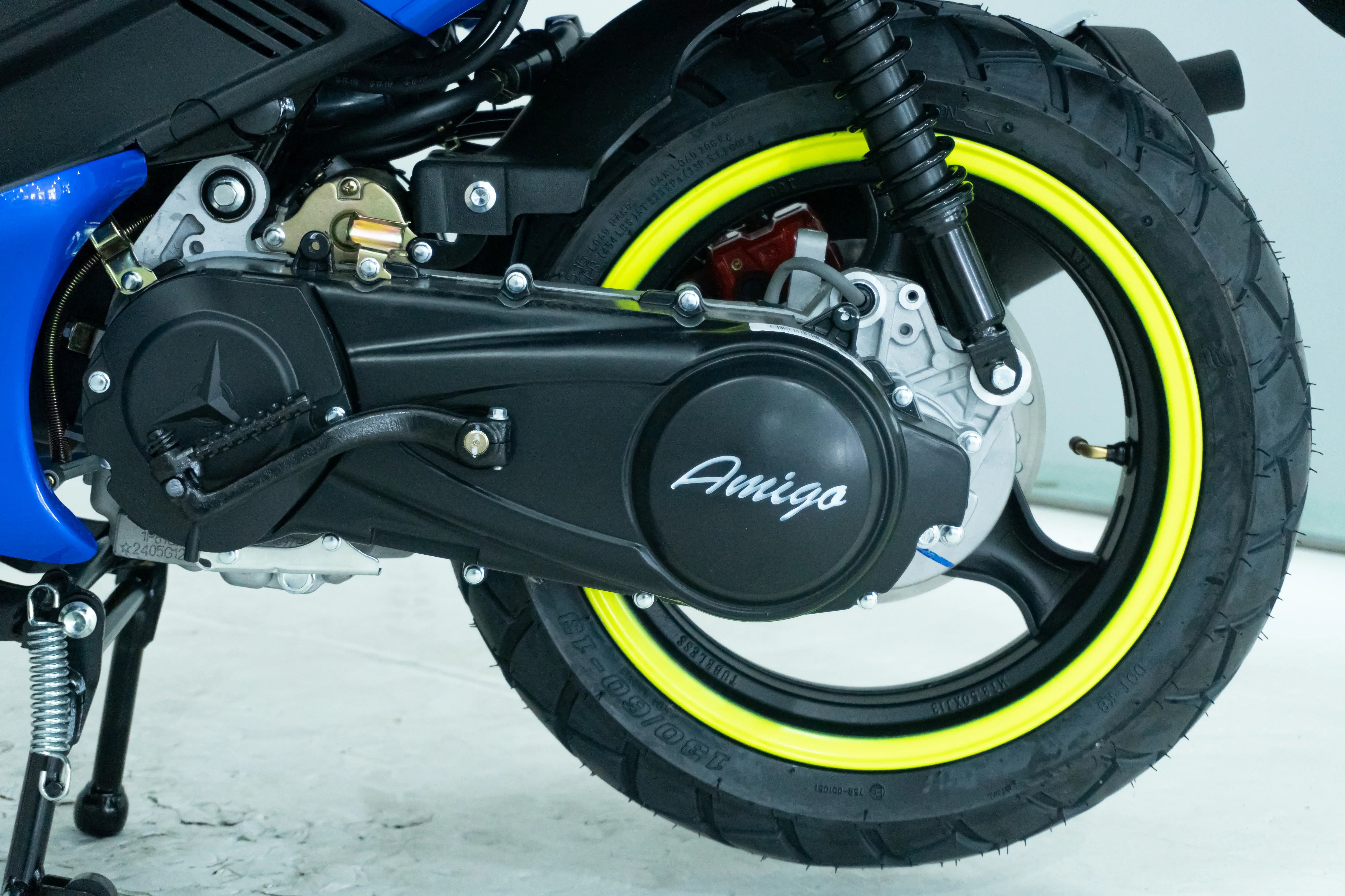 Amigo dirt bike with bright yellow rim and blue body, showcasing engine and suspension details