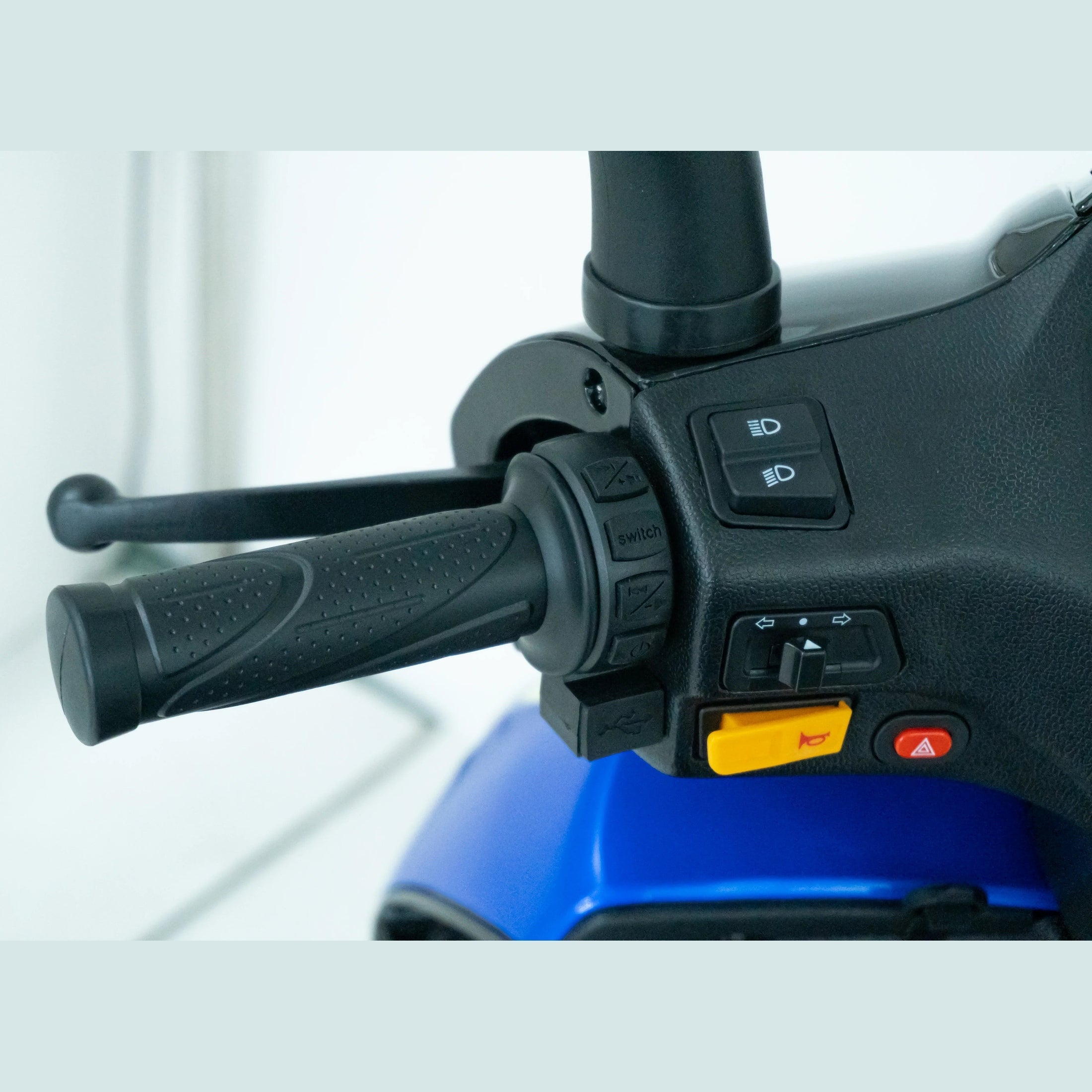 Close-up of ATV handlebar controls with switches, levers, and blue body panel
