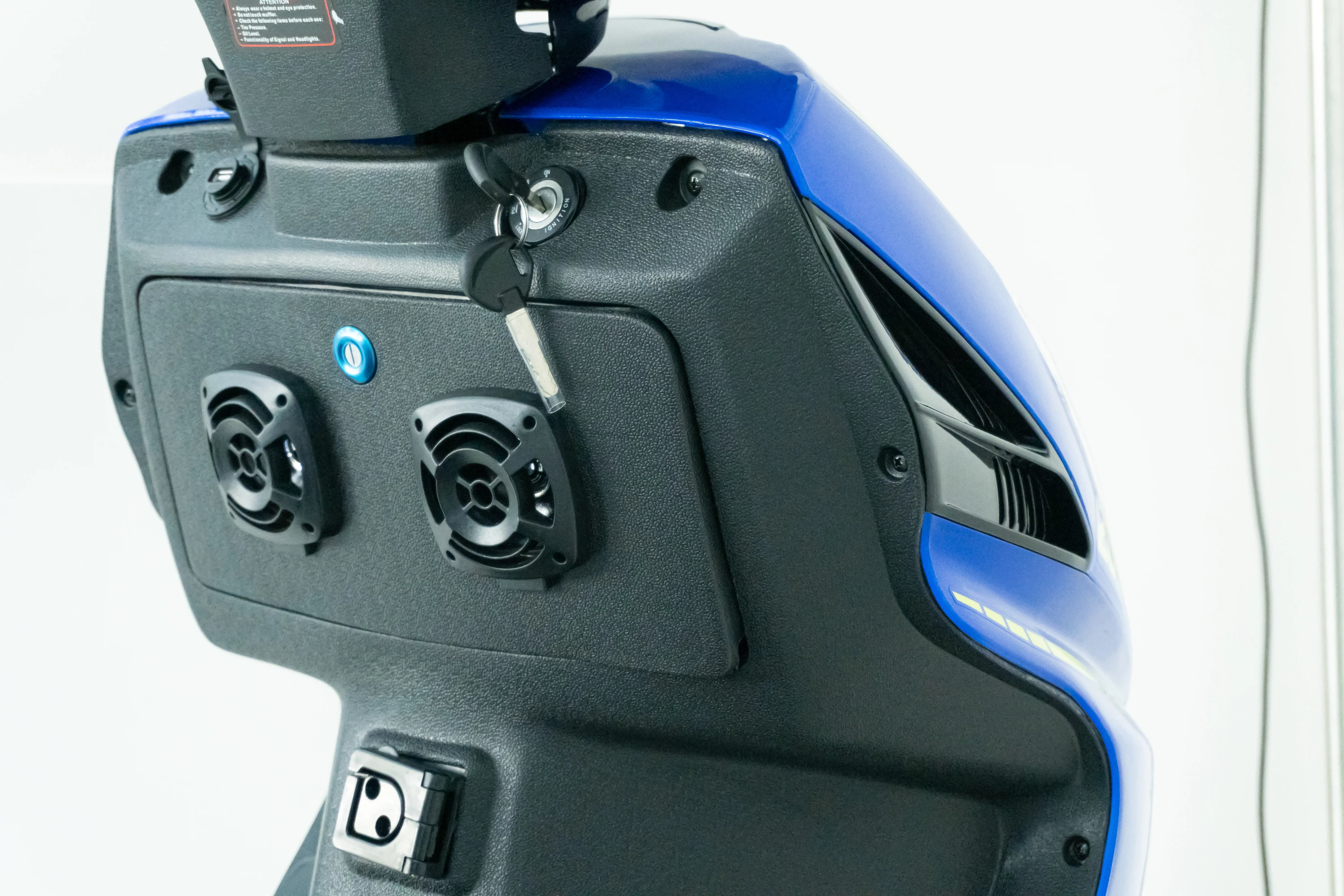 Blue and black scooter dashboard with key ignition and dual speakers