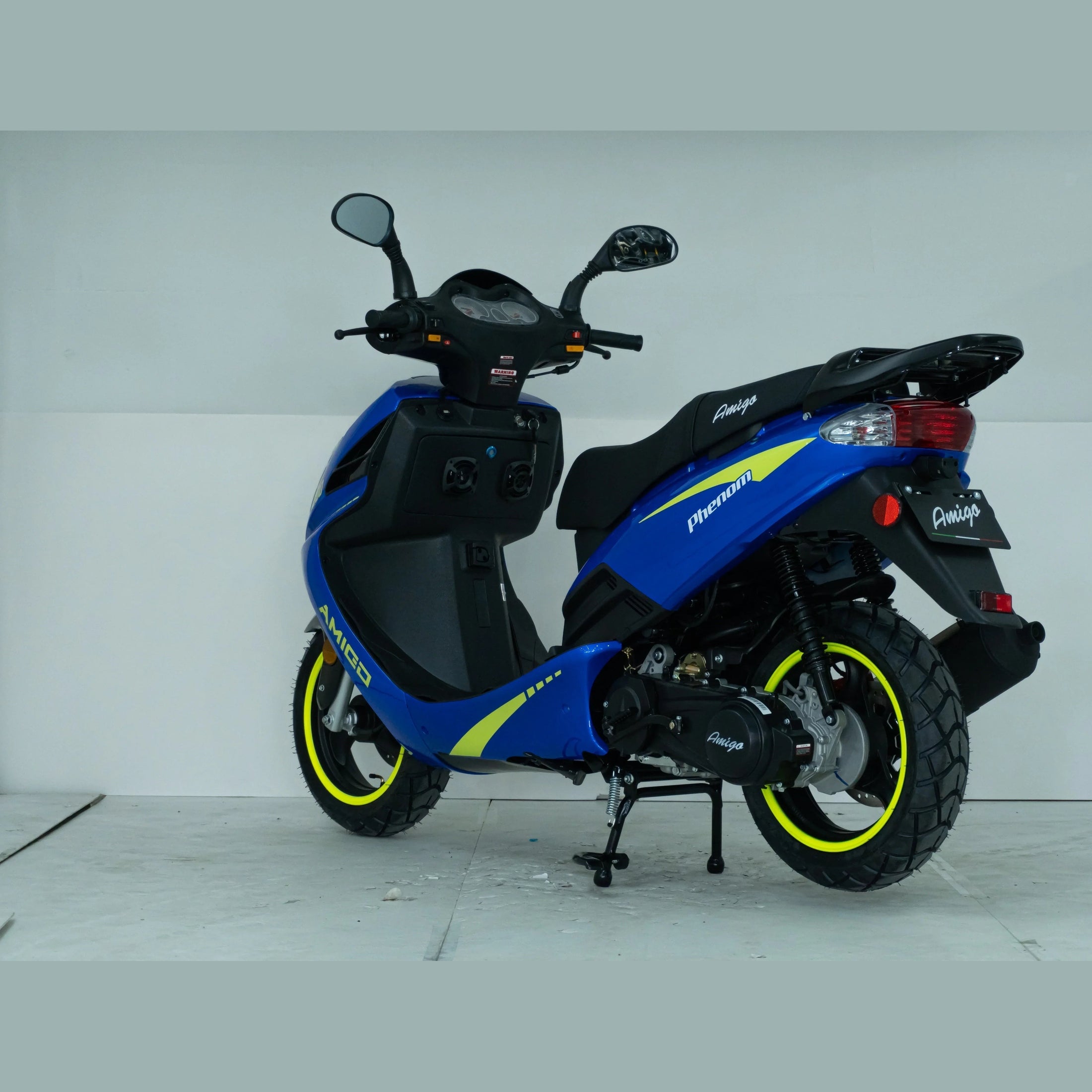 Blue and yellow Amigo Phenom scooter with sporty tires in a white indoor setting