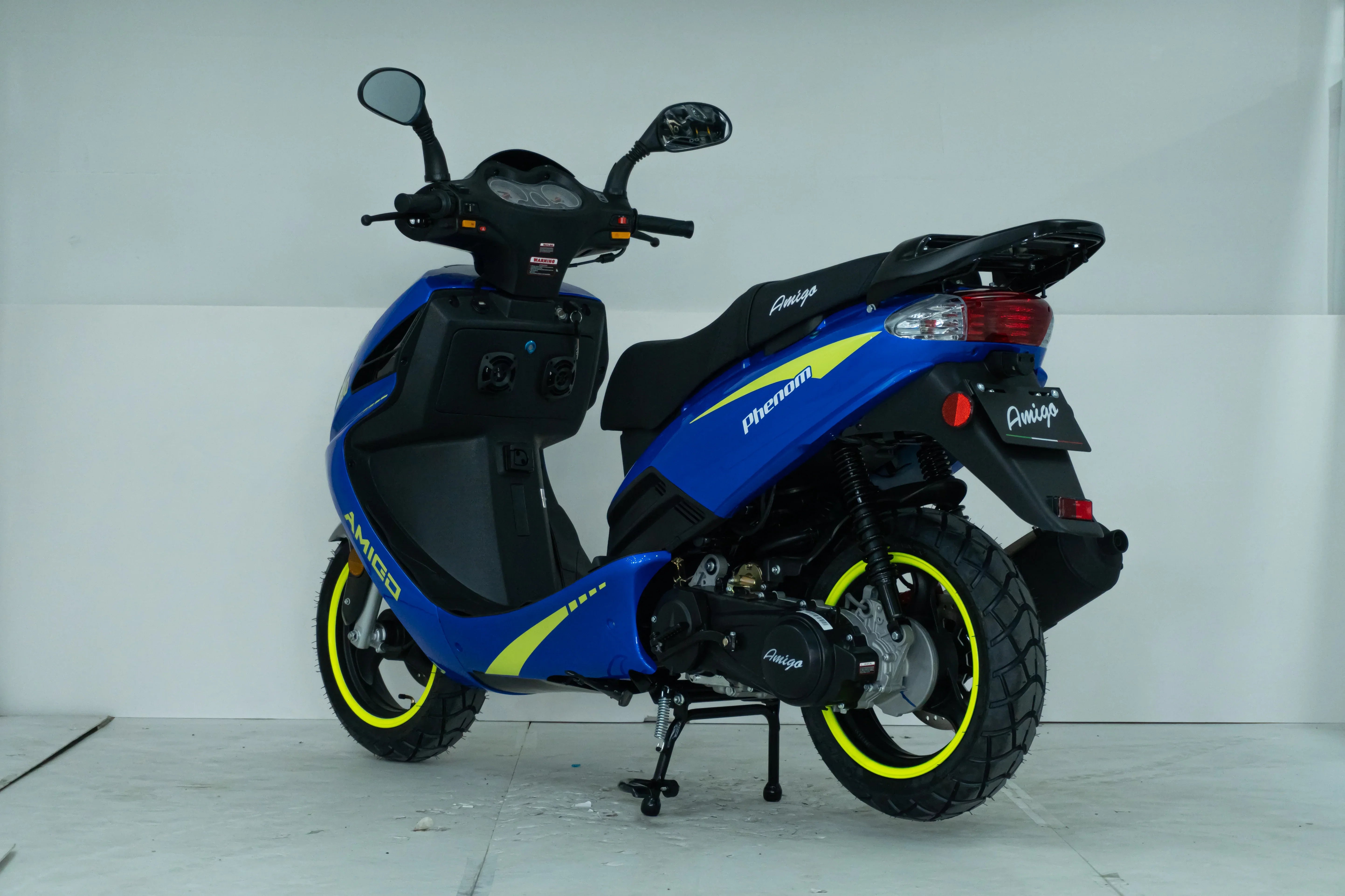 Blue Amigo Phenom scooter with yellow accents, displayed in a clean indoor setting.