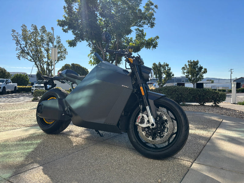 DAVINCI DC100 electric motorcycle front-three-quarter view with integrated headlight assembly