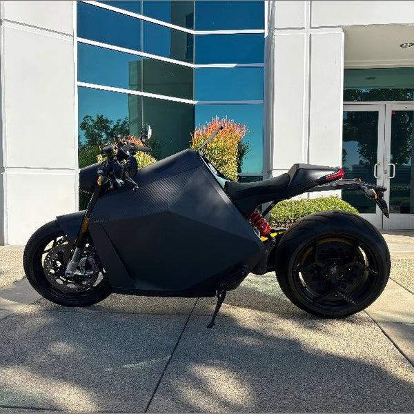 DAVINCI DC100 electric superbike parked outdoors with angular carbon fiber body design