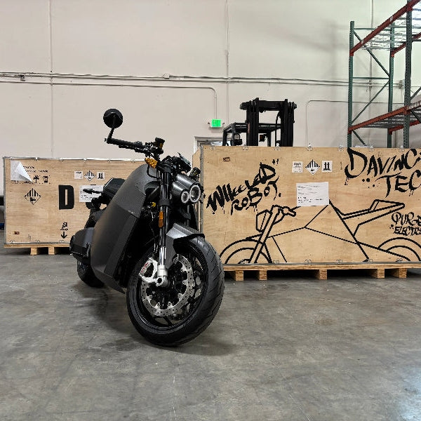 DAVINCI DC100 electric superbike three-quarter view with carbon fiber patterned panels
