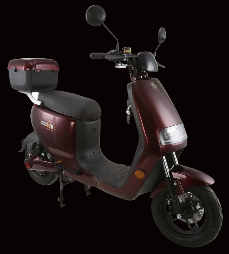 A maroon-colored Vitacci E-RUNNER electric scooter with a black seat, front disc brake, rear drum brake, and a storage compartment at the back.