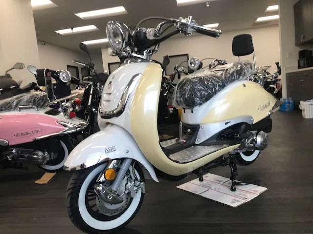 Cream white retro-style electric scooter with ABS brakes displayed in showroom