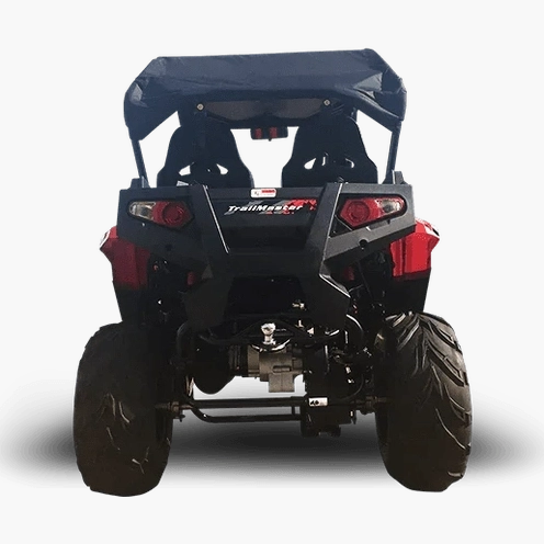 Rear view of red TrailMaster UTV showing brush guard, taillights, and treaded tires