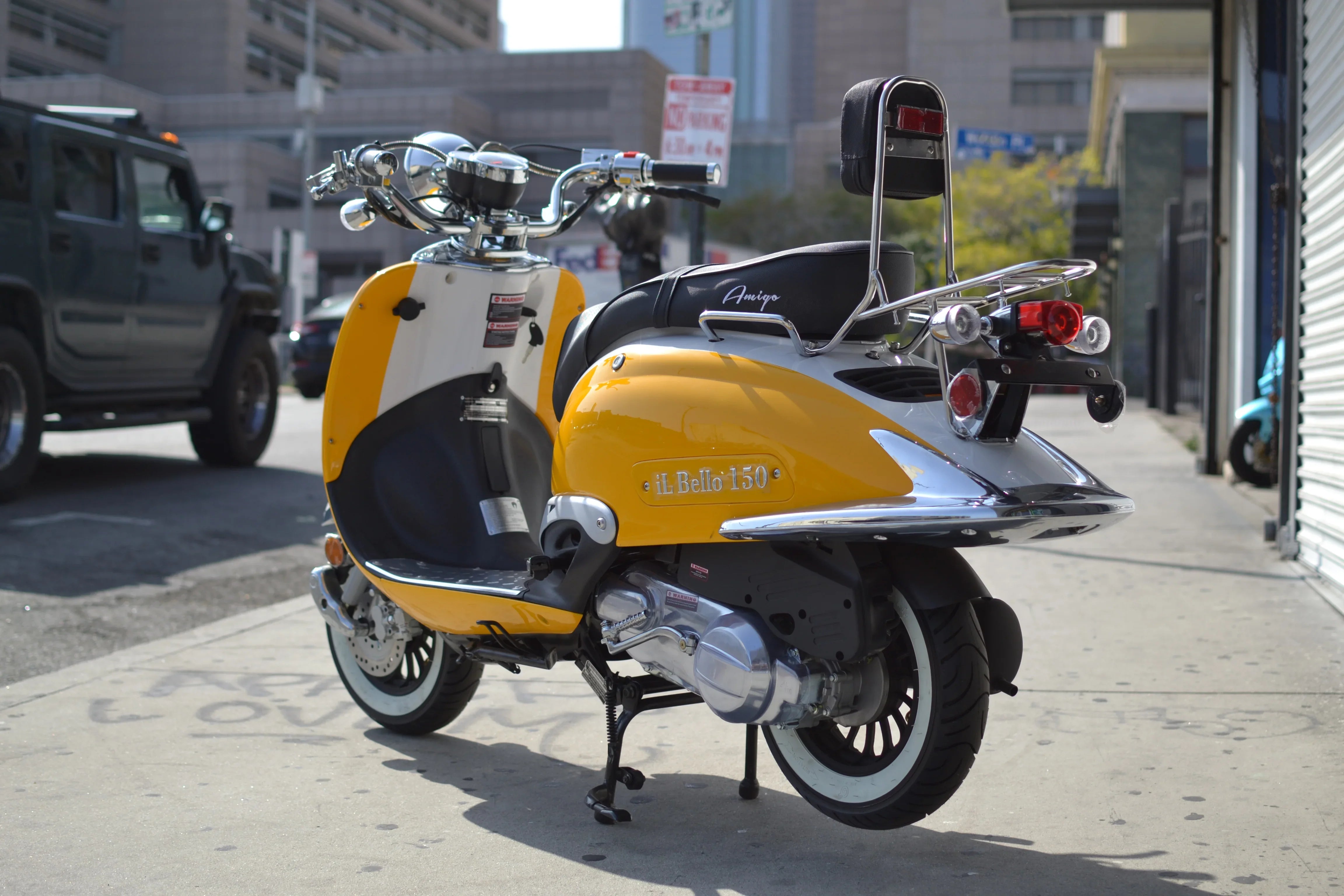 Yellow and white Amigo iL Bello 150cc scooter parked on city sidewalk