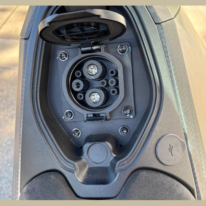 DAVINCI DC100 electric motorcycle charging port with multi-pin socket and USB-C cap
