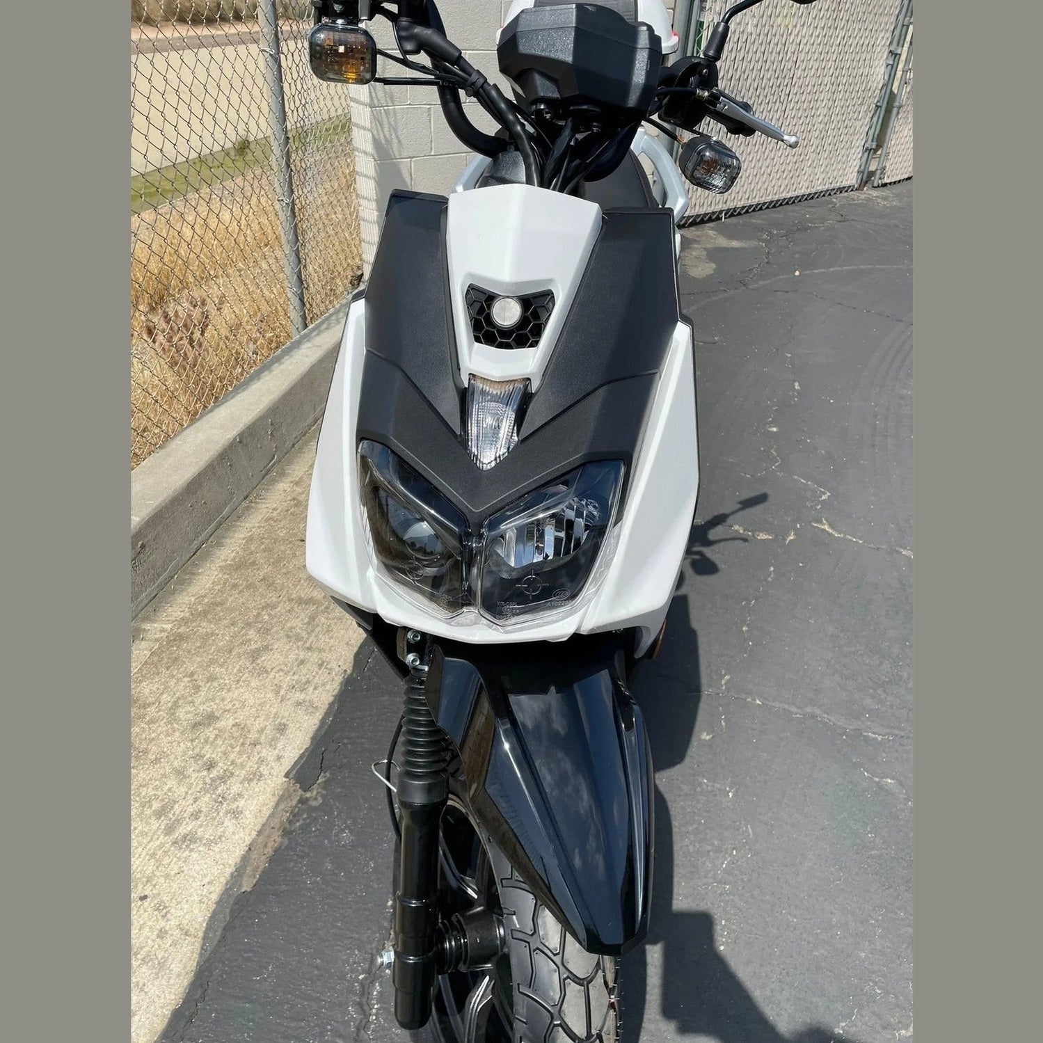 Front view of white Ranger 150cc scooter dual headlights and grille