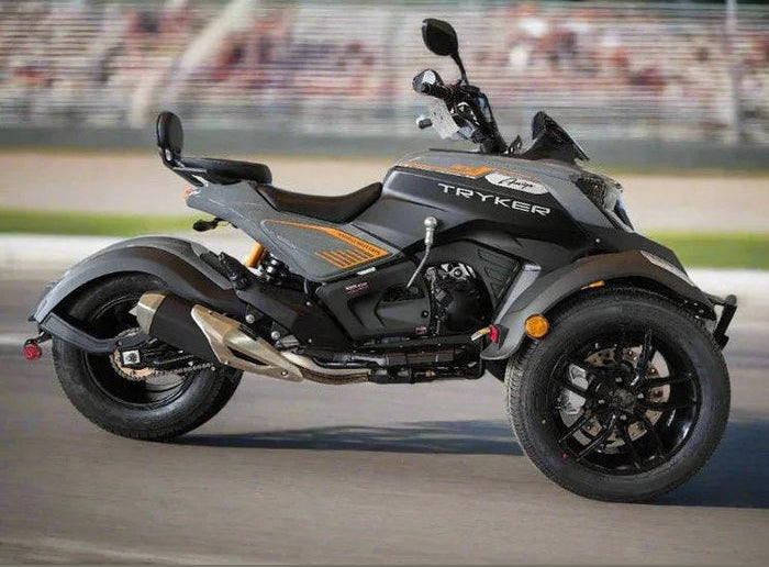 Gray Amigo Tryker 300cc trike in motion on paved road with orange accents