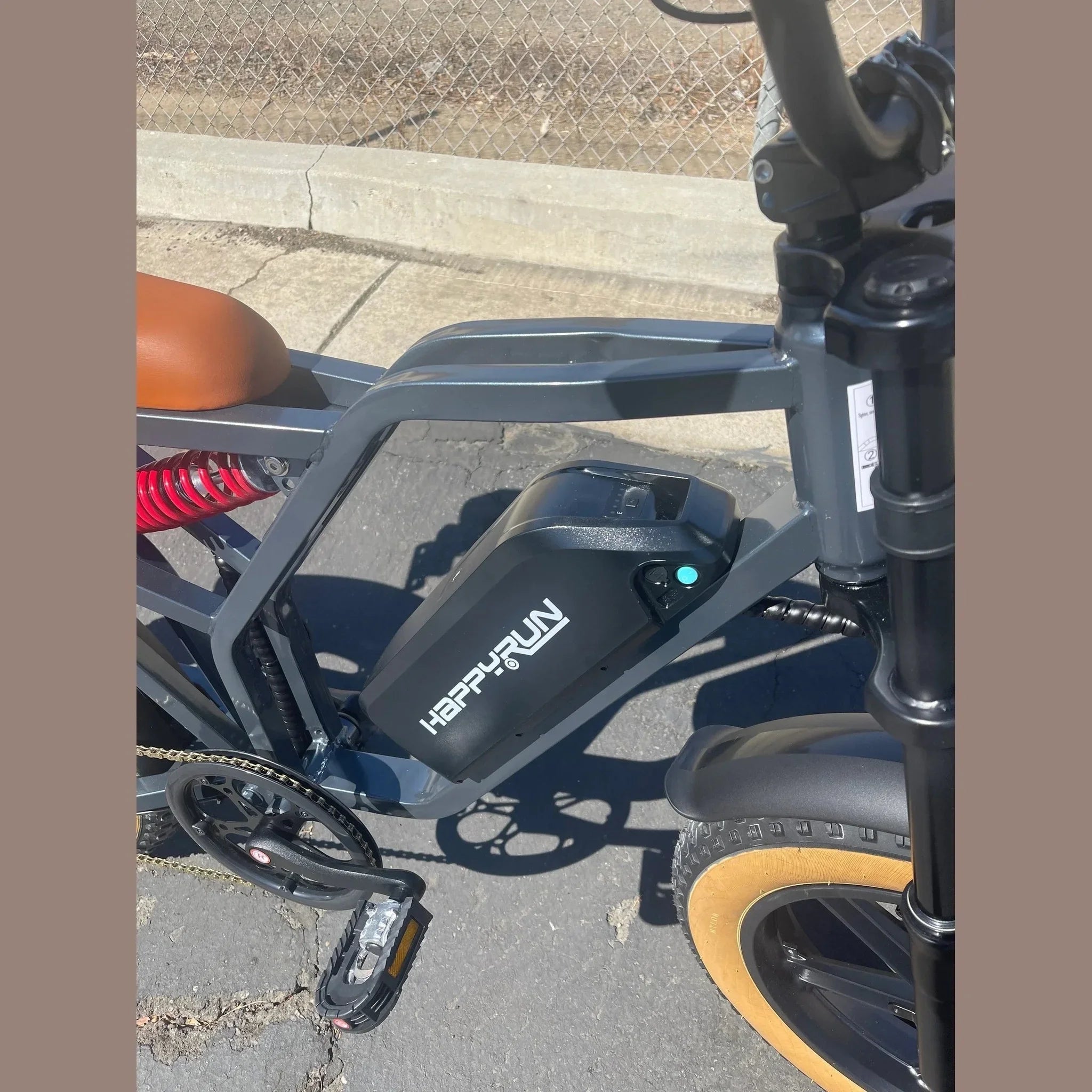 Close-up of HAPPYRUN branded battery pack on down tube with LED indicator
