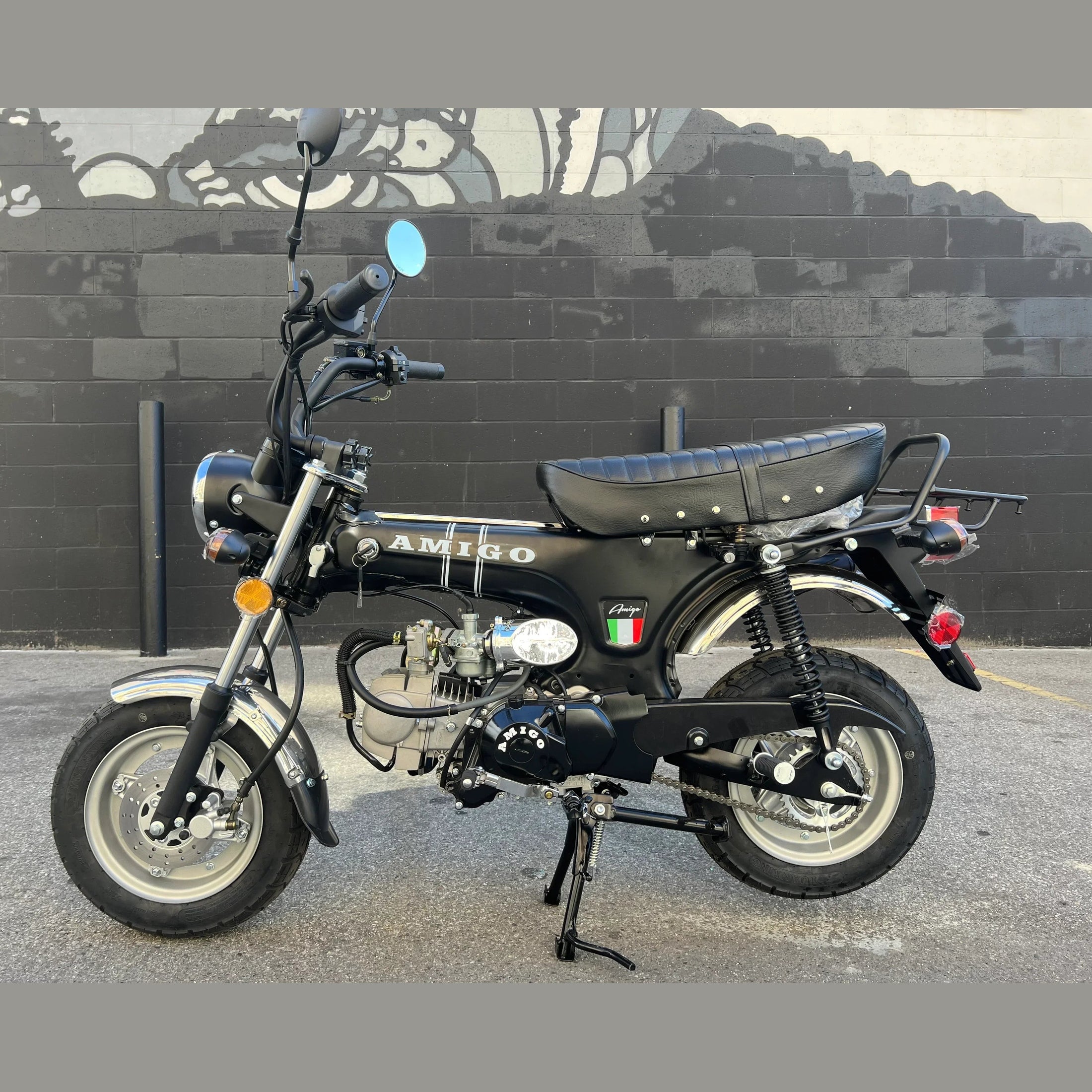 Black Amigo Rocky 125cc mini motorcycle outdoor shot against brick wall