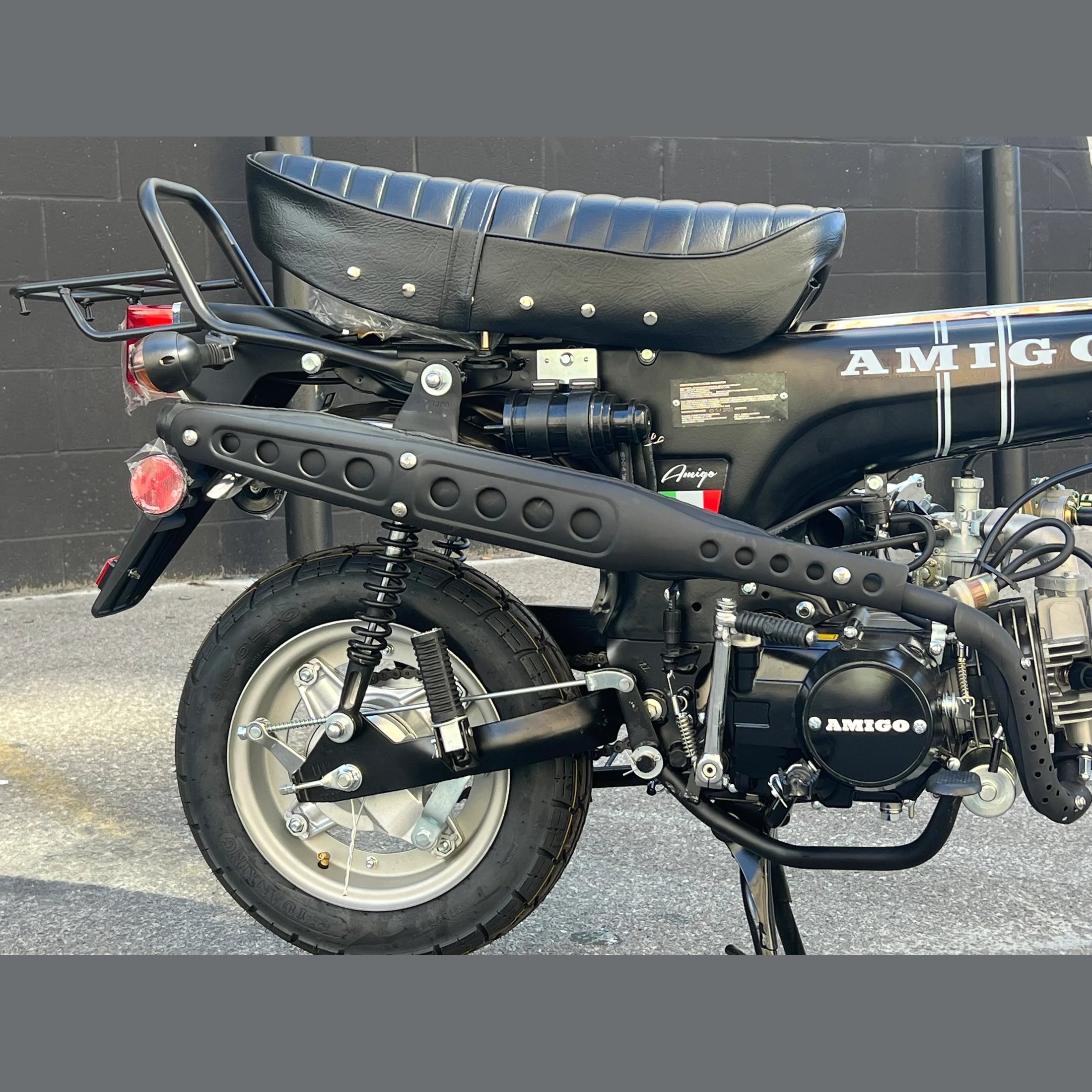 Black Amigo mini motorcycle rear view with ribbed seat and perforated exhaust pipe