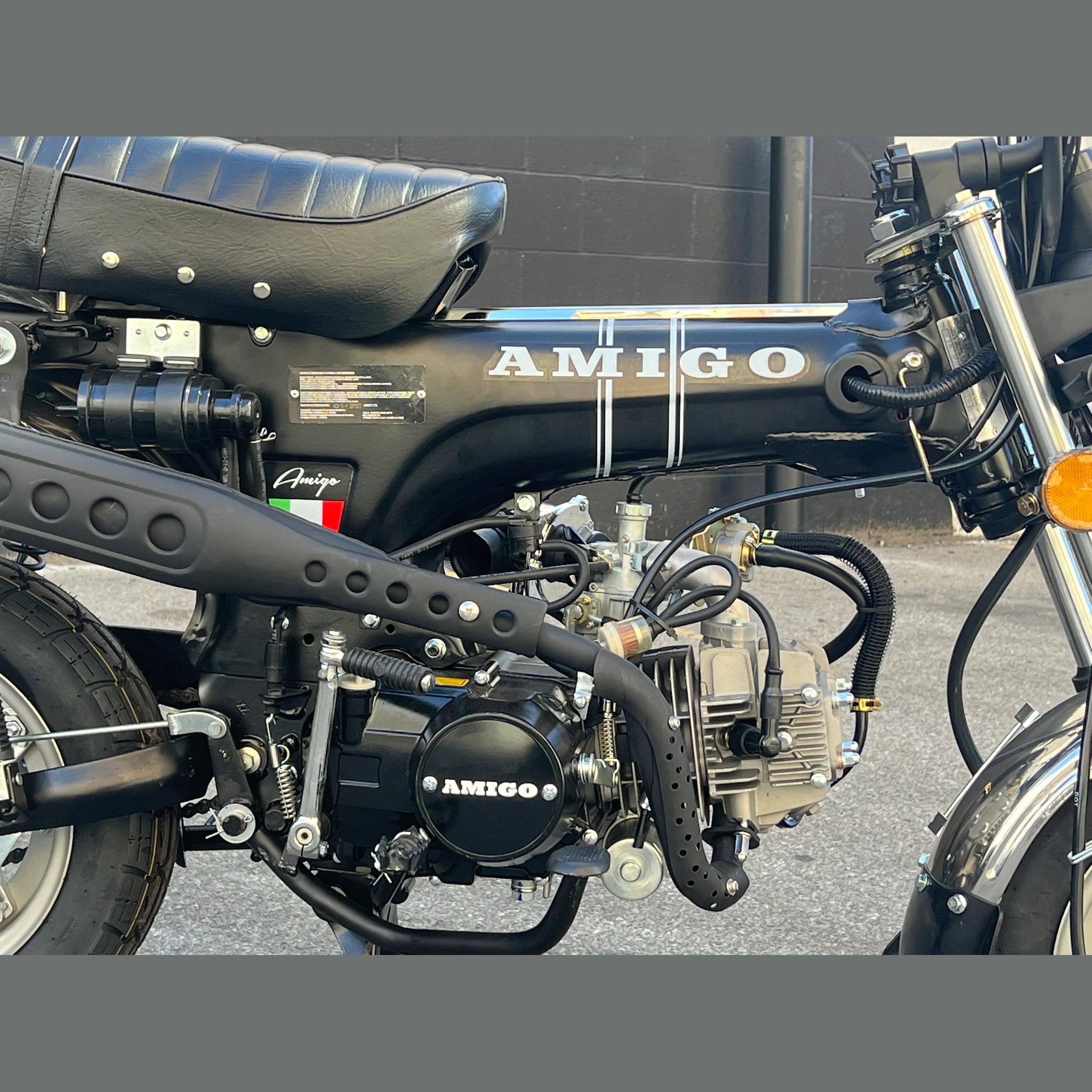 Black Amigo mini motorcycle engine detail shot with carburetor and striped fuel tank