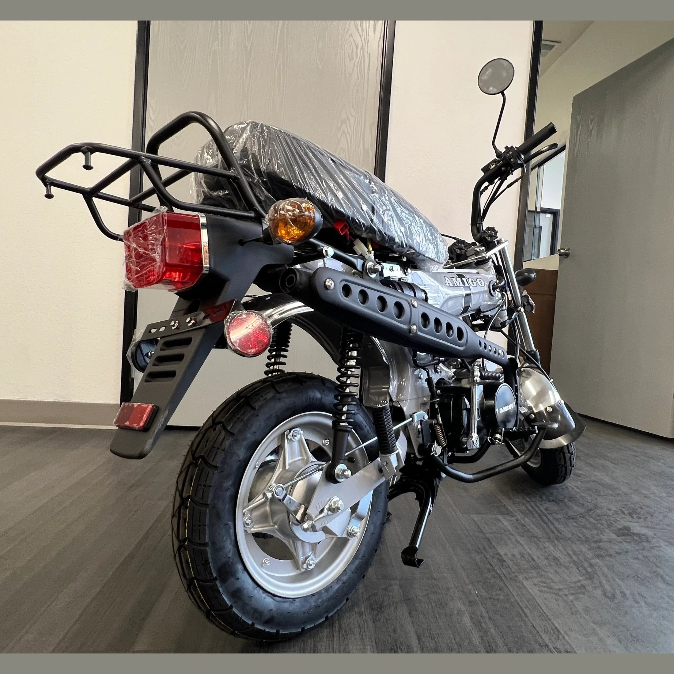 Silver Amigo mini bike rear three-quarter view with chrome exhaust and ventilation slots