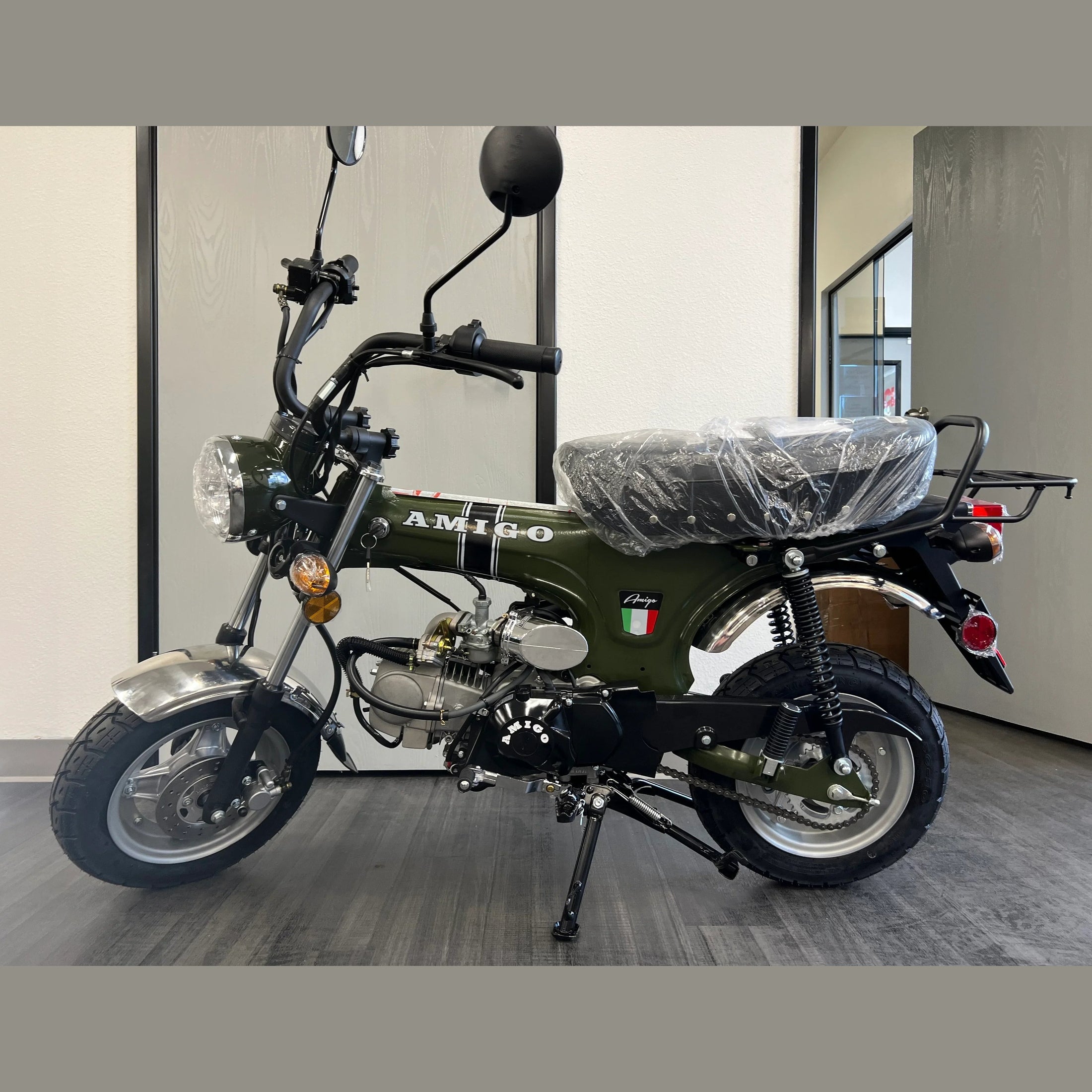 Olive green Amigo 125cc mini motorcycle side profile with dual shock absorbers and rack