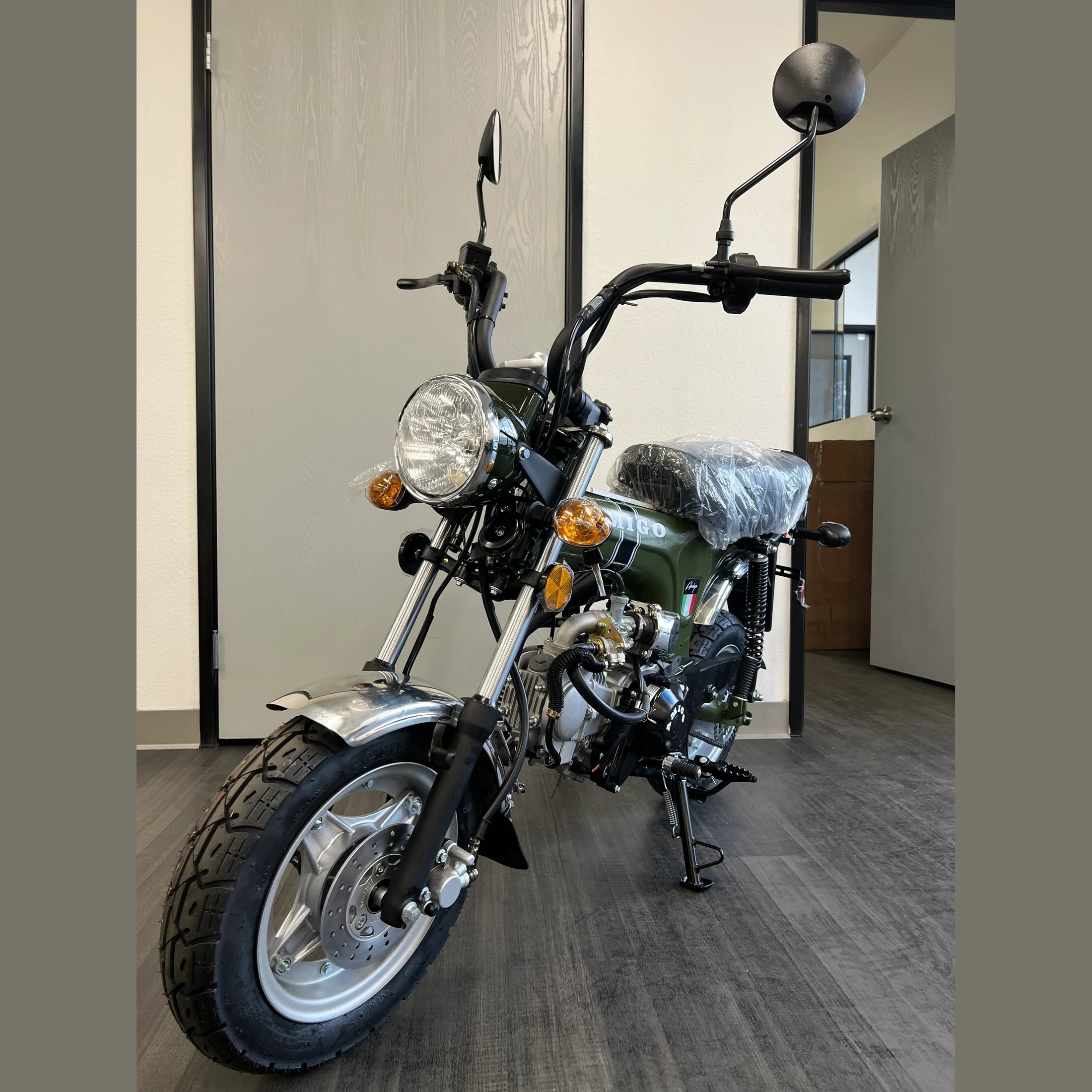 Olive green Amigo Rocky 125cc mini bike angled view with visible suspension springs