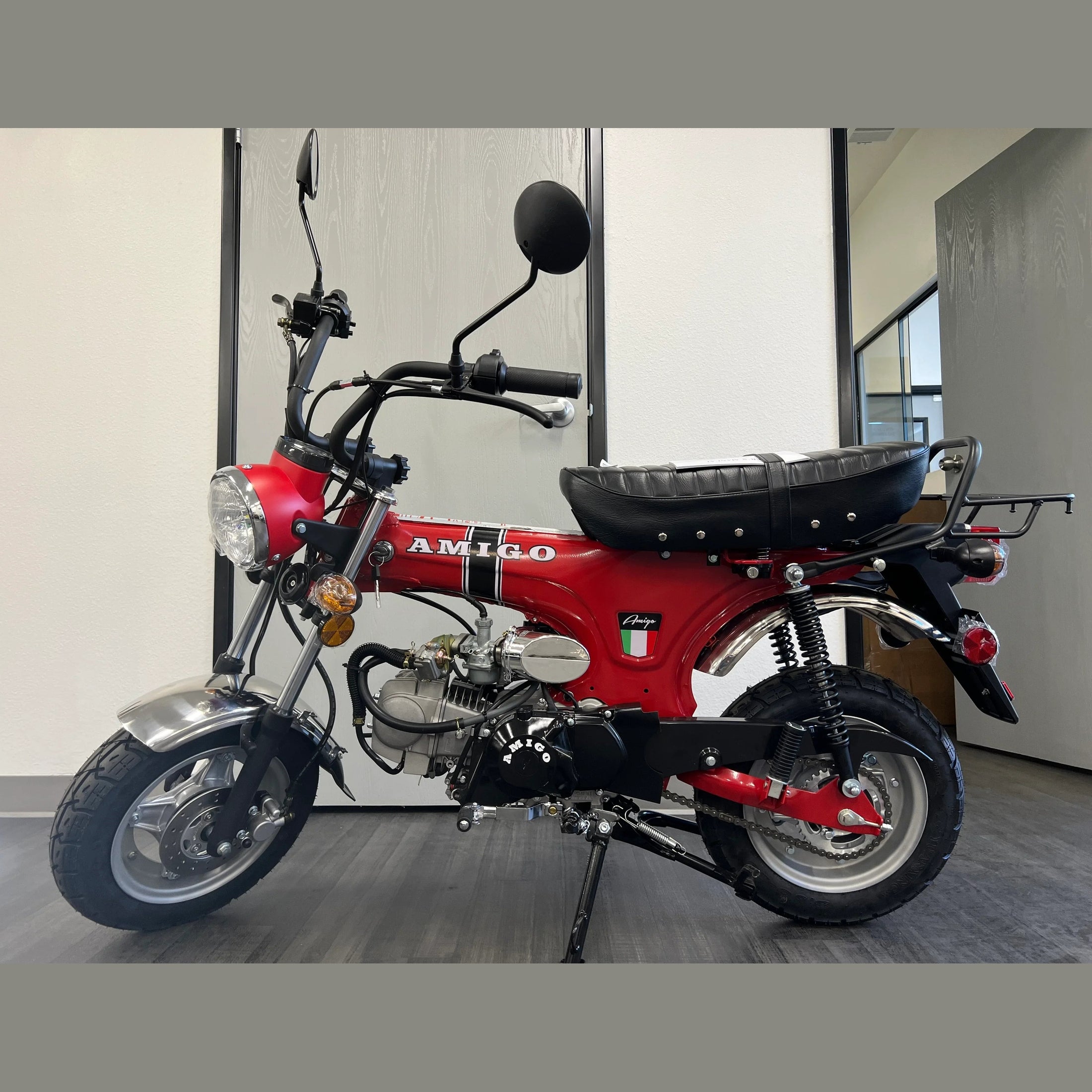 Red Amigo Rocky 125cc mini bike with chrome fenders and Italian flag sticker indoors