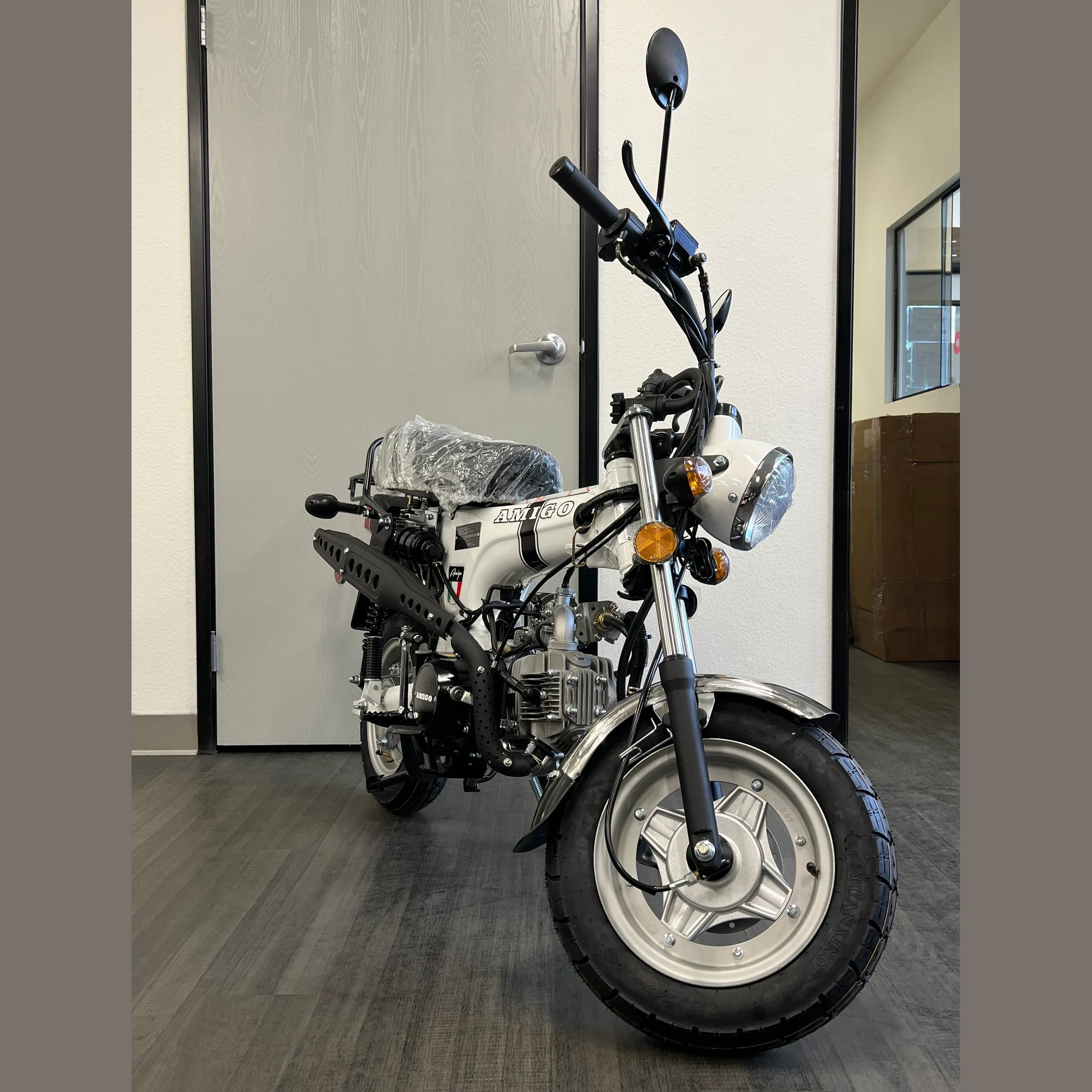 White Amigo Rocky 125cc mini bike front view with cardboard box background