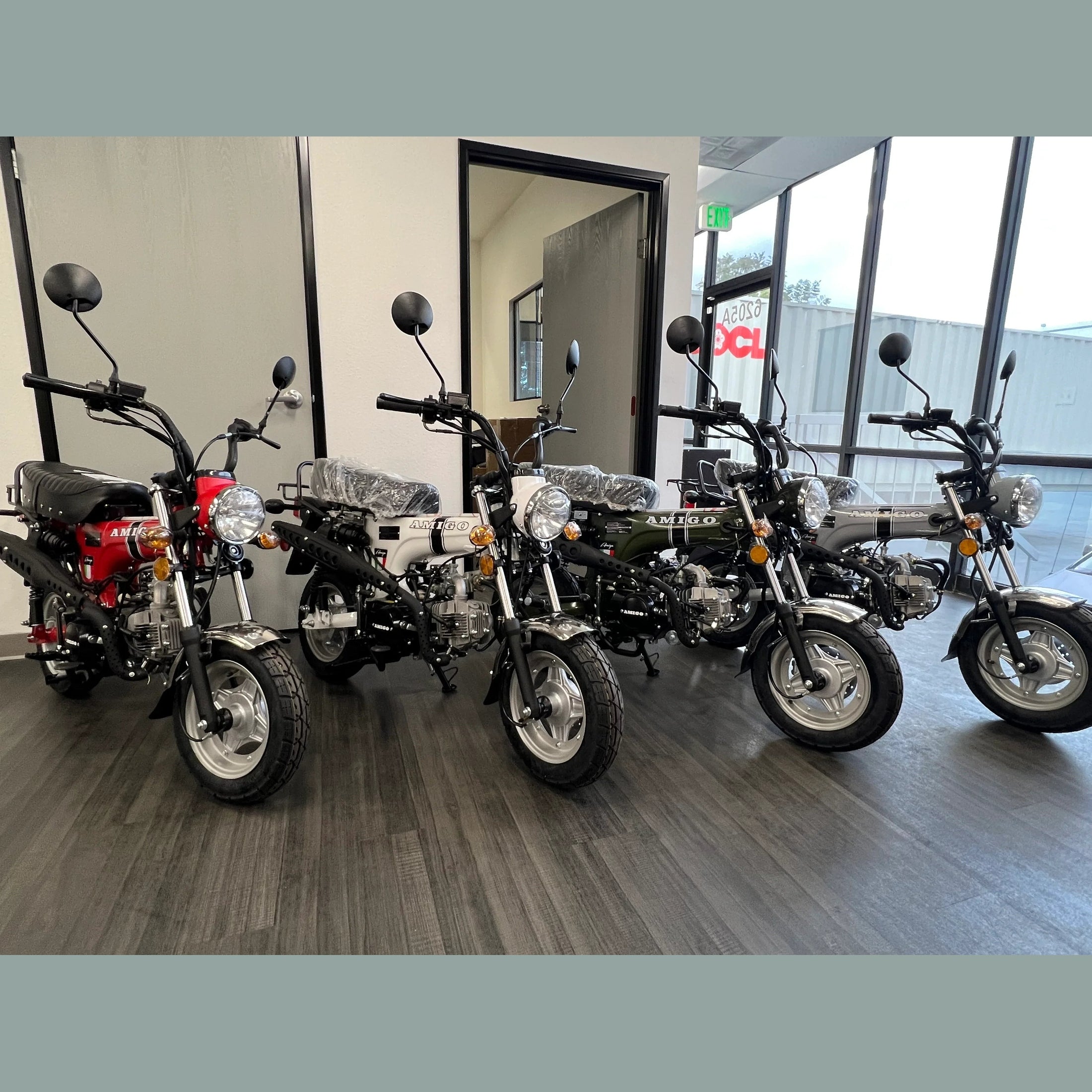 Row of five Amigo mini motorcycles in red, white, green, gray, and black colors