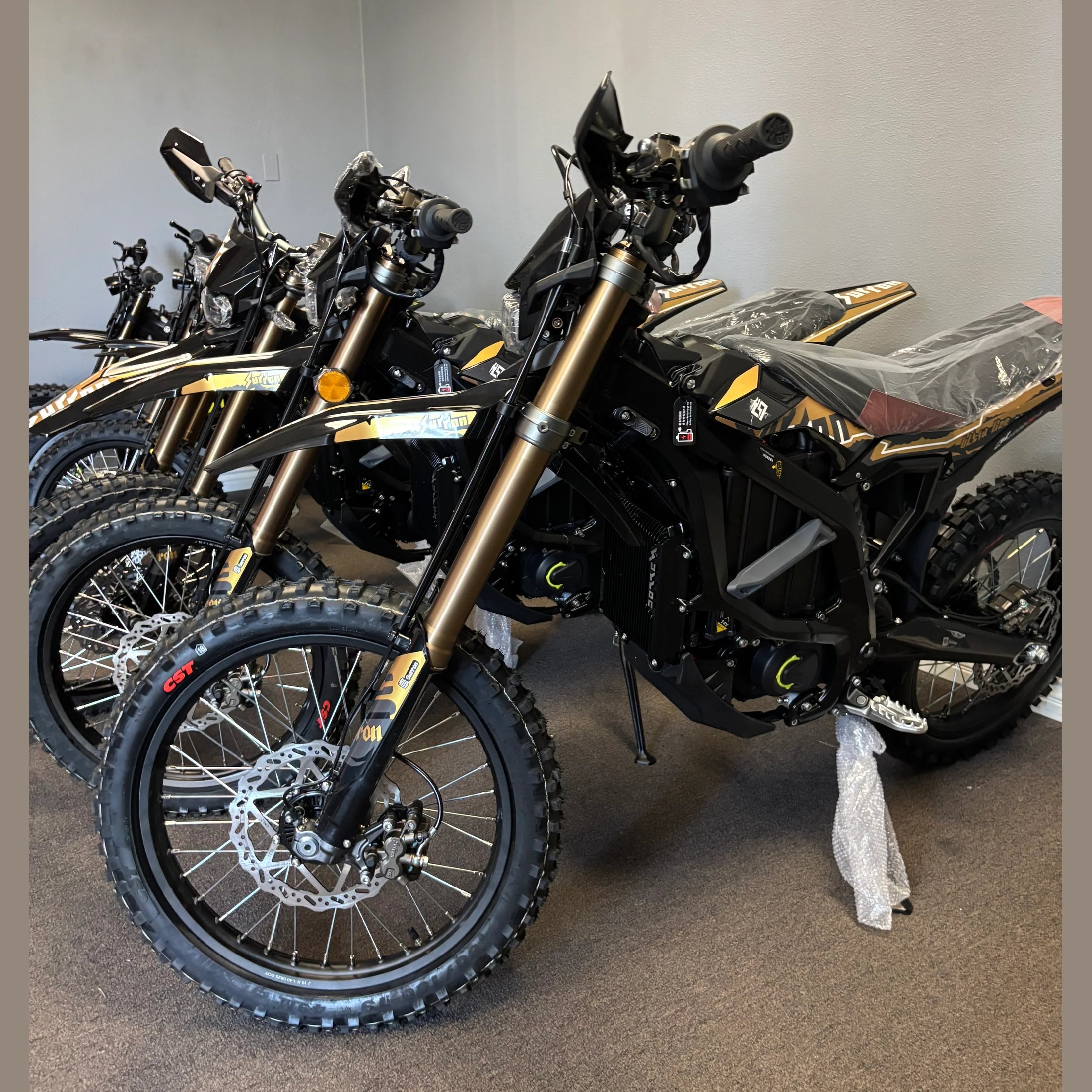 Black Surron Ultra Bee R electric dirt bike with gold forks and knobby tires