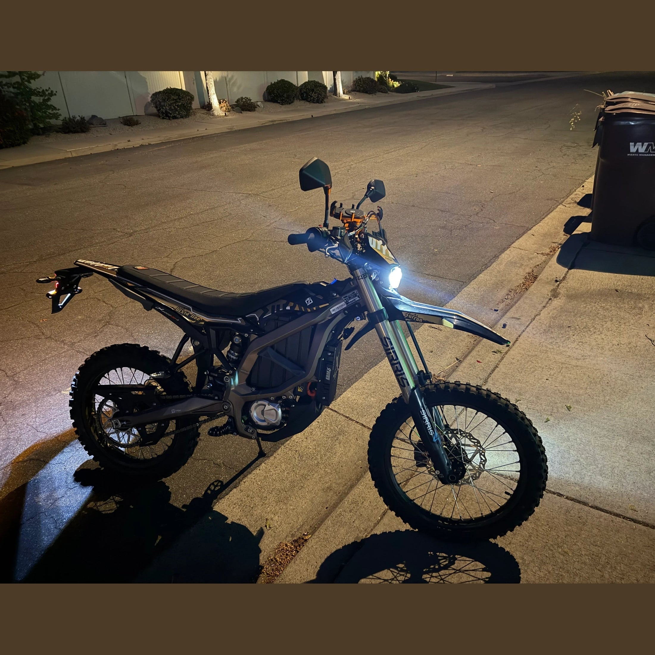 Surron Ultra Bee R electric dirt bike at night with headlight illuminated