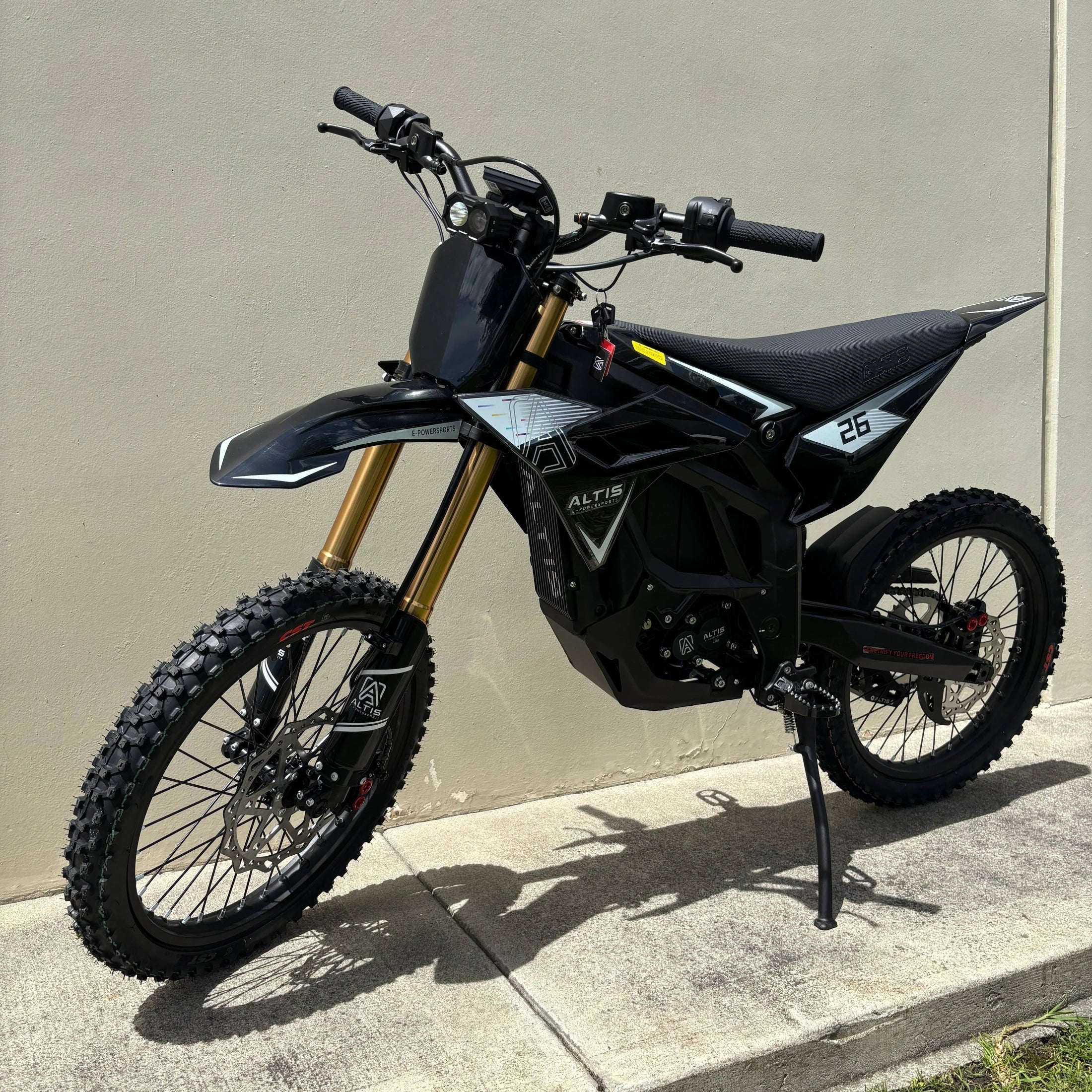 front three-quarter view of black Atlis Sigma electric dirt bike with knobby tires