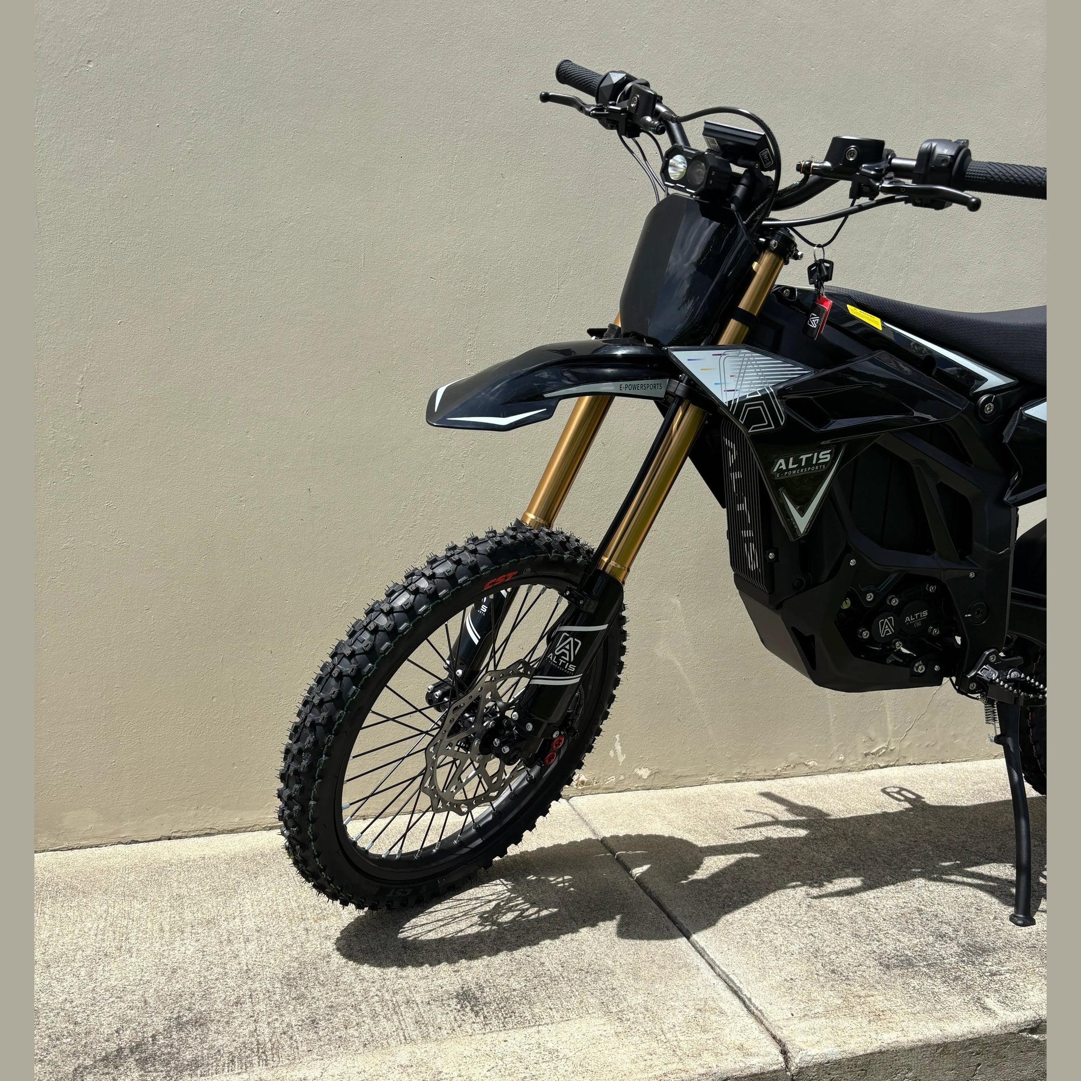 side view of black Atlis Sigma electric dirt bike featuring white graphics and disc brakes