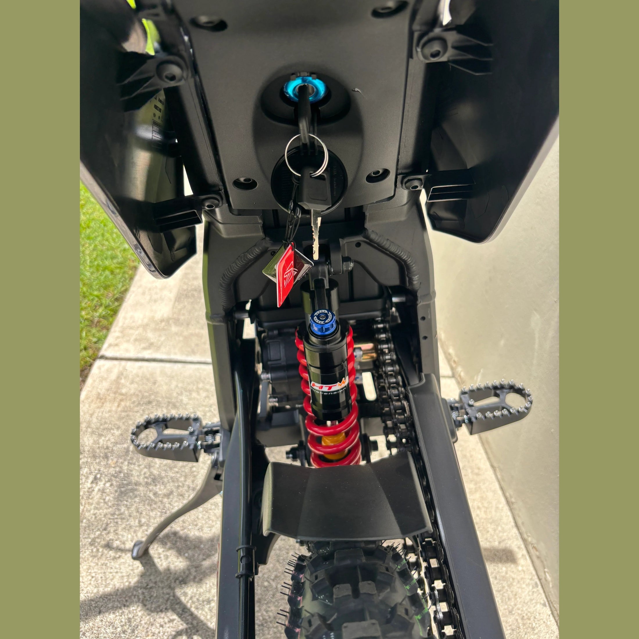 rear view of black Atlis Sigma e-bike showing red coil shock and illuminated ignition