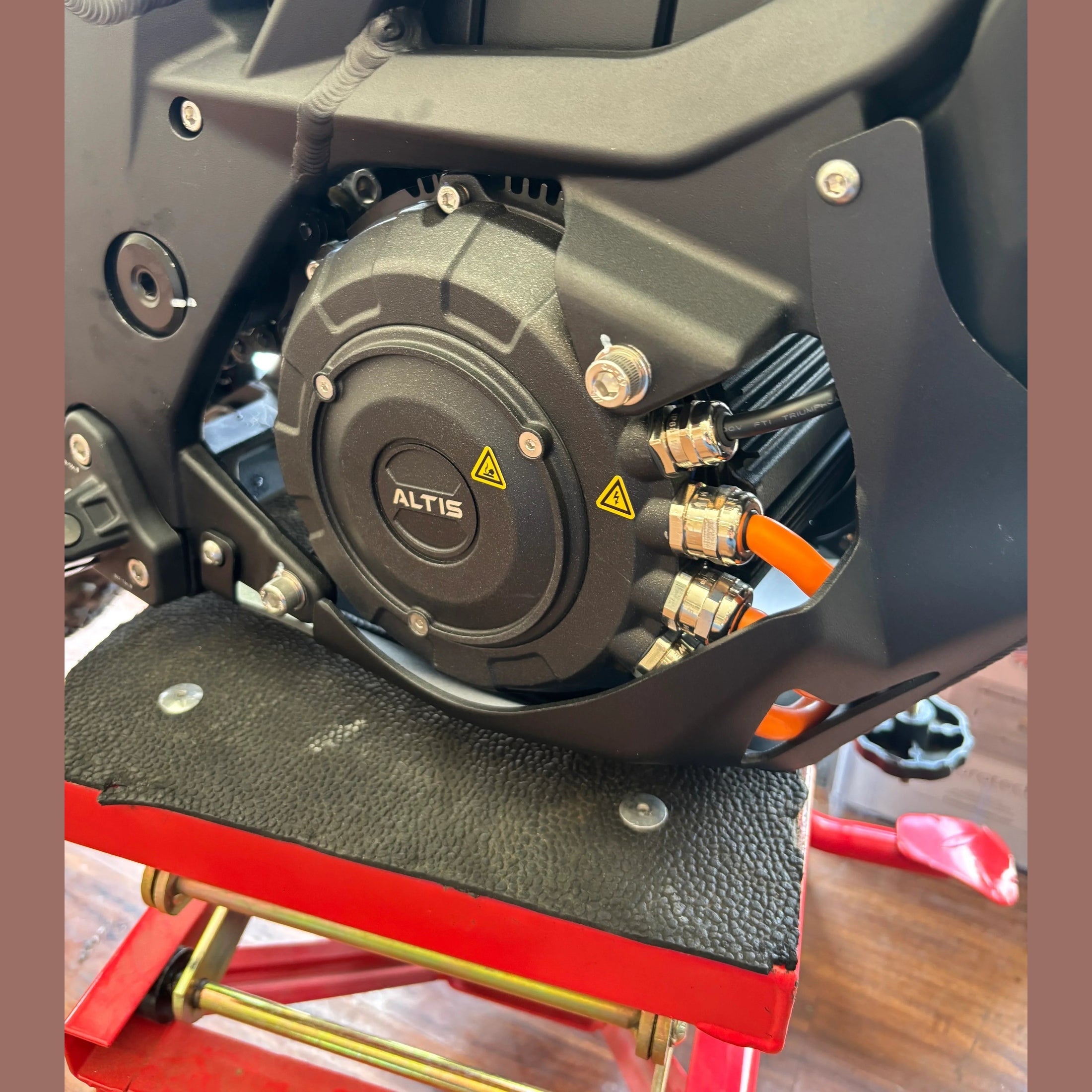 close-up of black Altis hairpin motor assembly with orange high-voltage cables