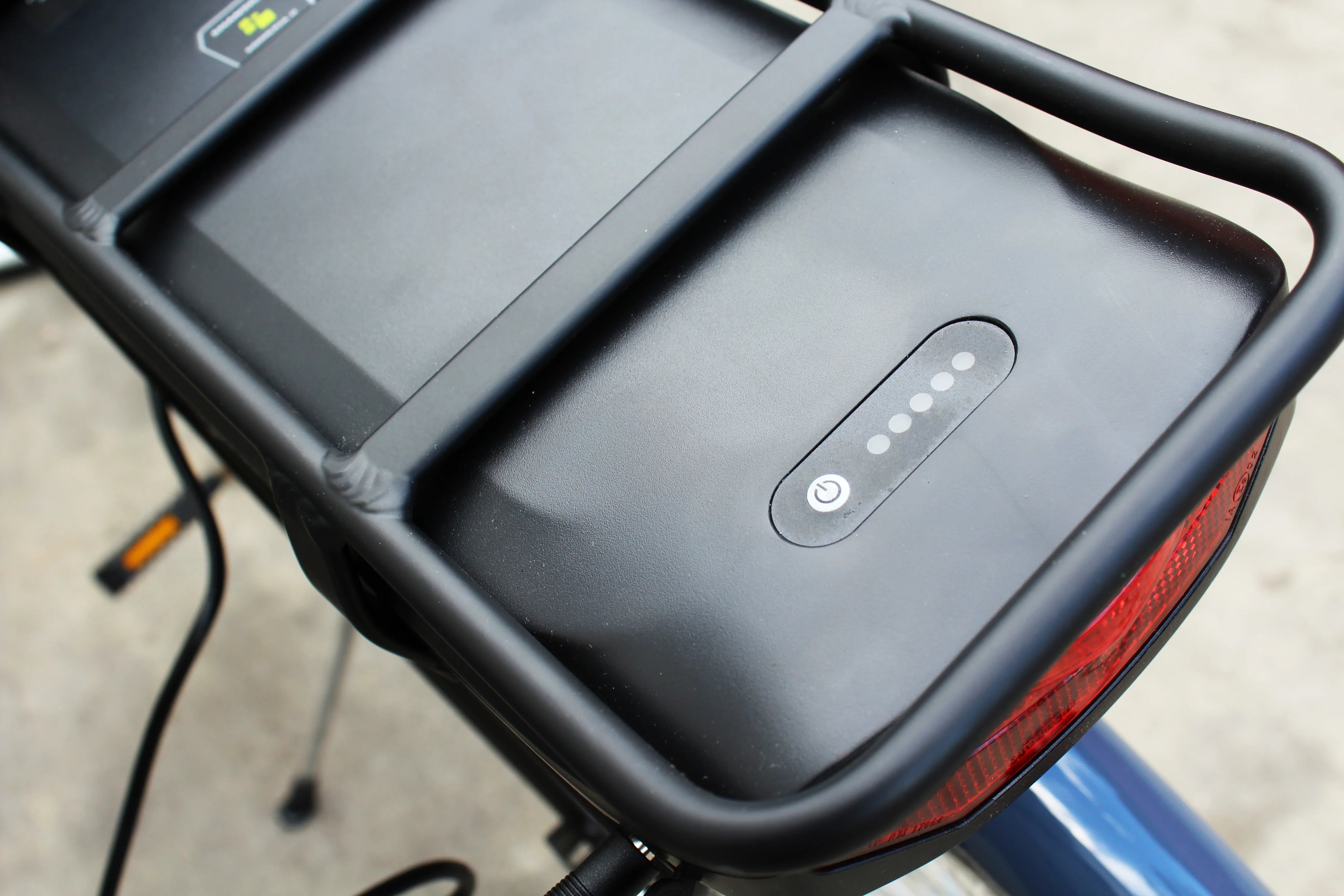 Close-up of black rear battery pack with LED indicators on electric bike