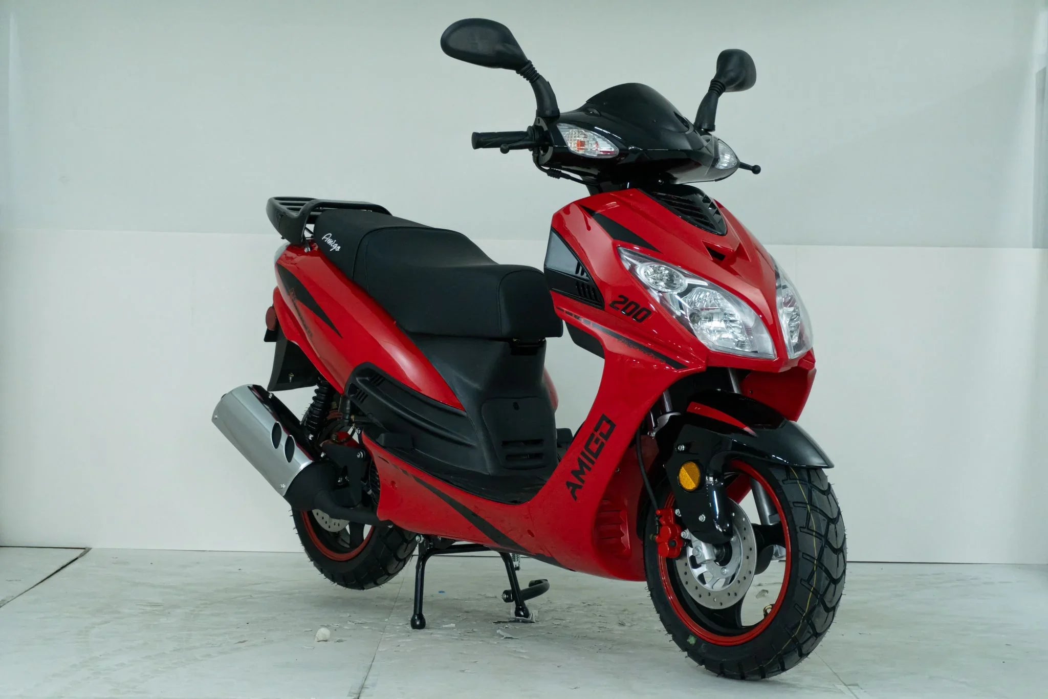 Red Amigo 200 scooter with black accents and disc brakes, ideal for urban commuting.