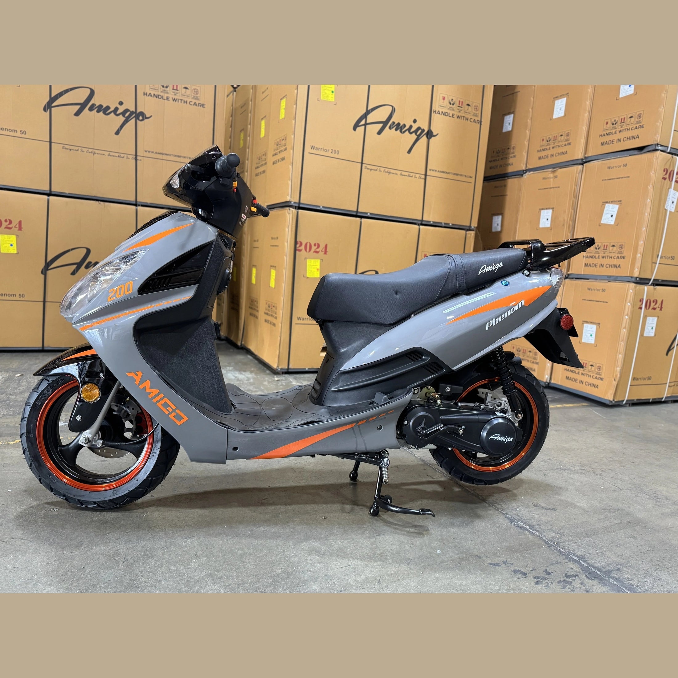 Gray Amigo Phenom 200cc scooter with orange accents in warehouse, side view