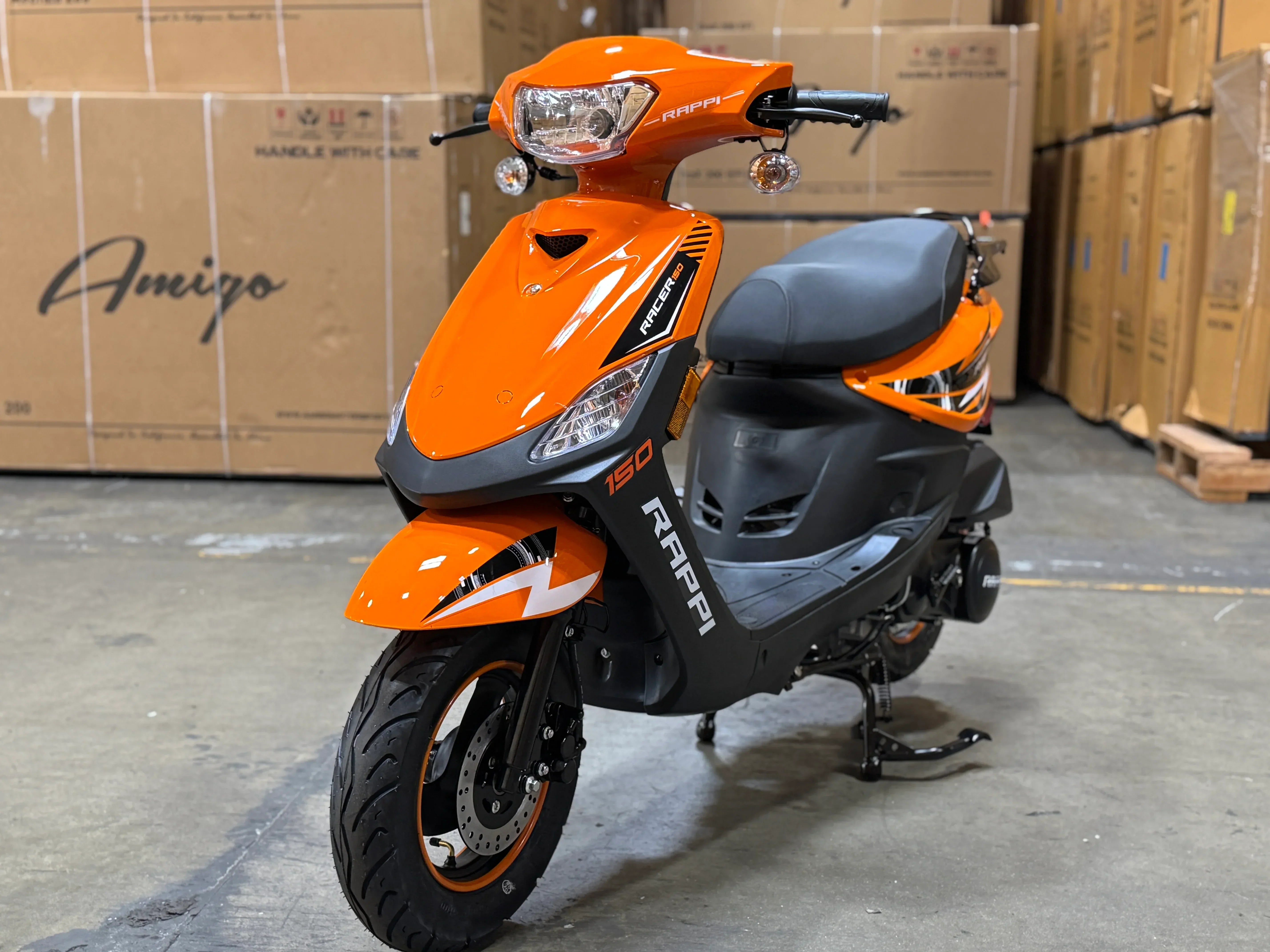 Orange RAPPI 150cc scooter with black accents, parked in a warehouse setting.
