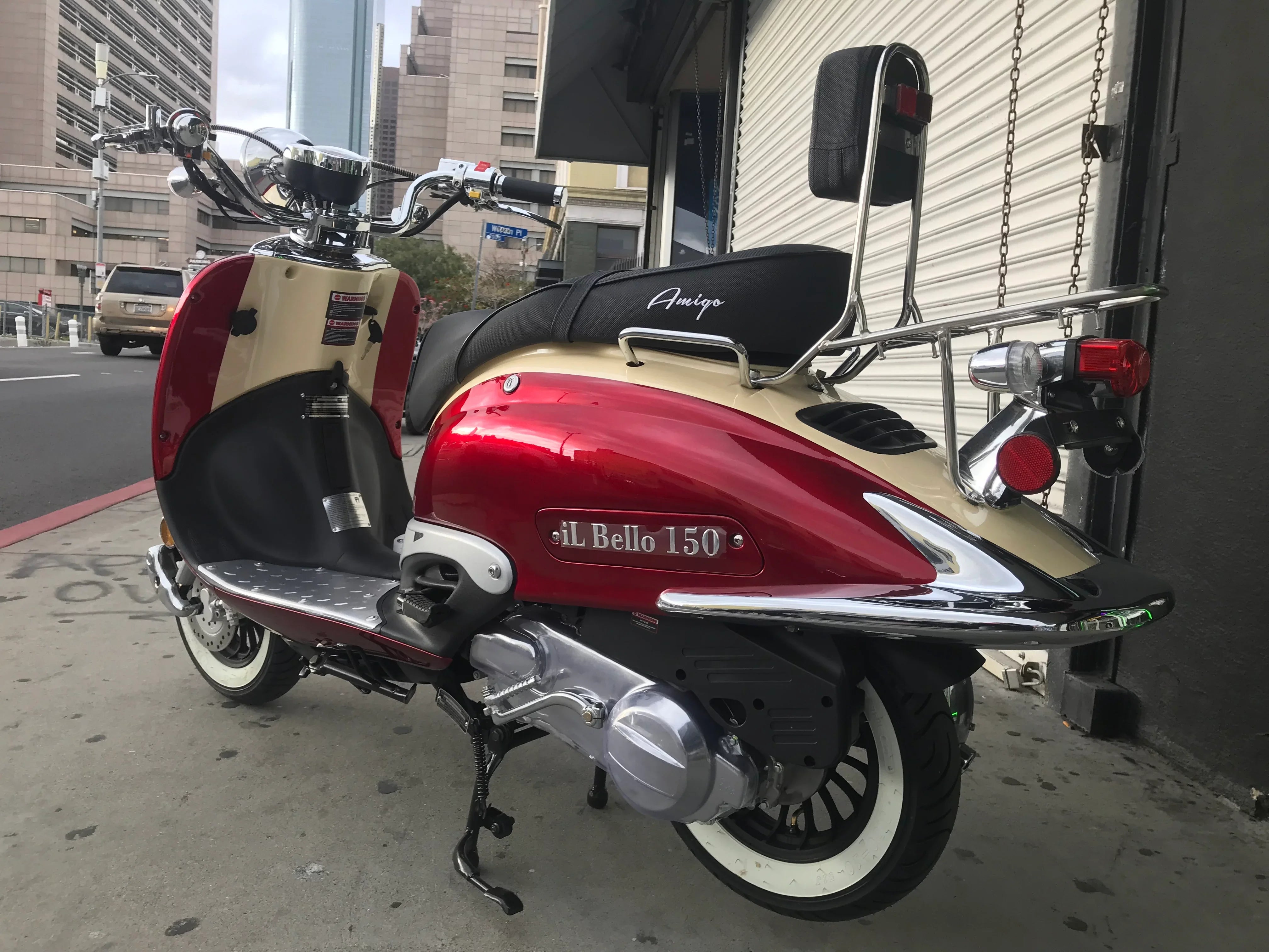 Red and cream Amigo IL Bello 150cc scooter parked on city street, retro design, chrome accents