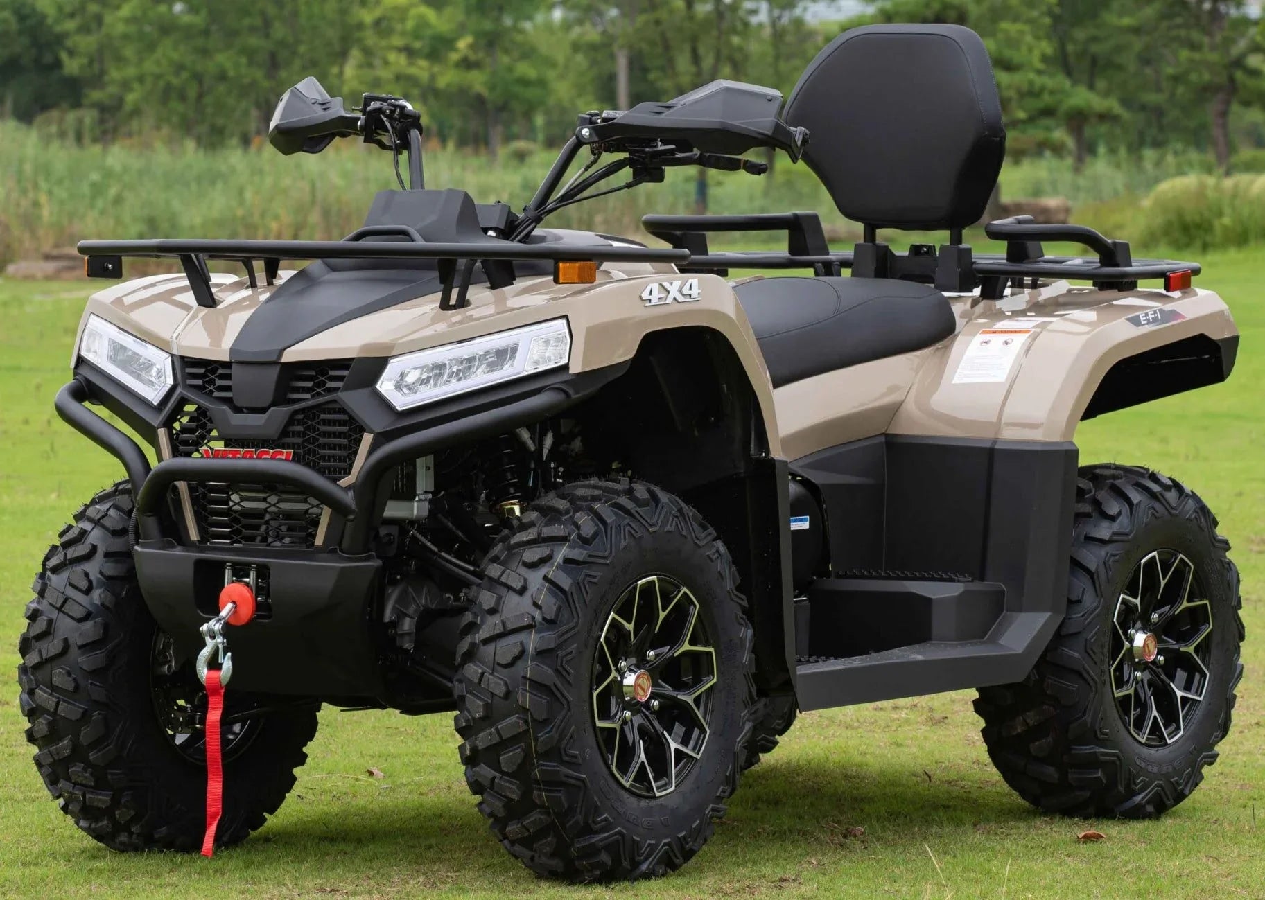 Tan MAXIMUS 450L EFI 4x4 ATV with black accents, rugged tires, and rear cargo rack parked on grass