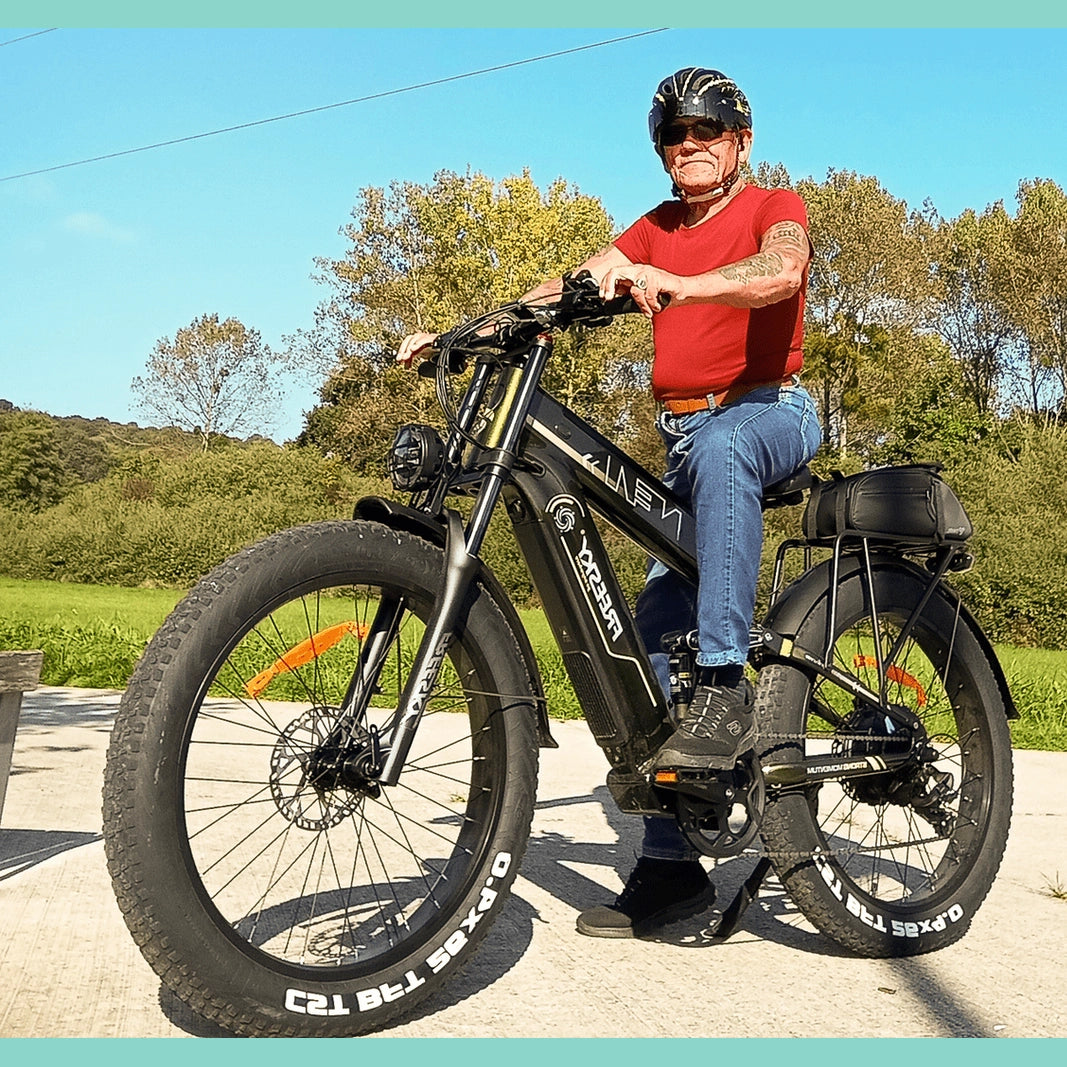 Man sitting on black Freesky electric fat tire bike with saddlebag on paved outdoor path