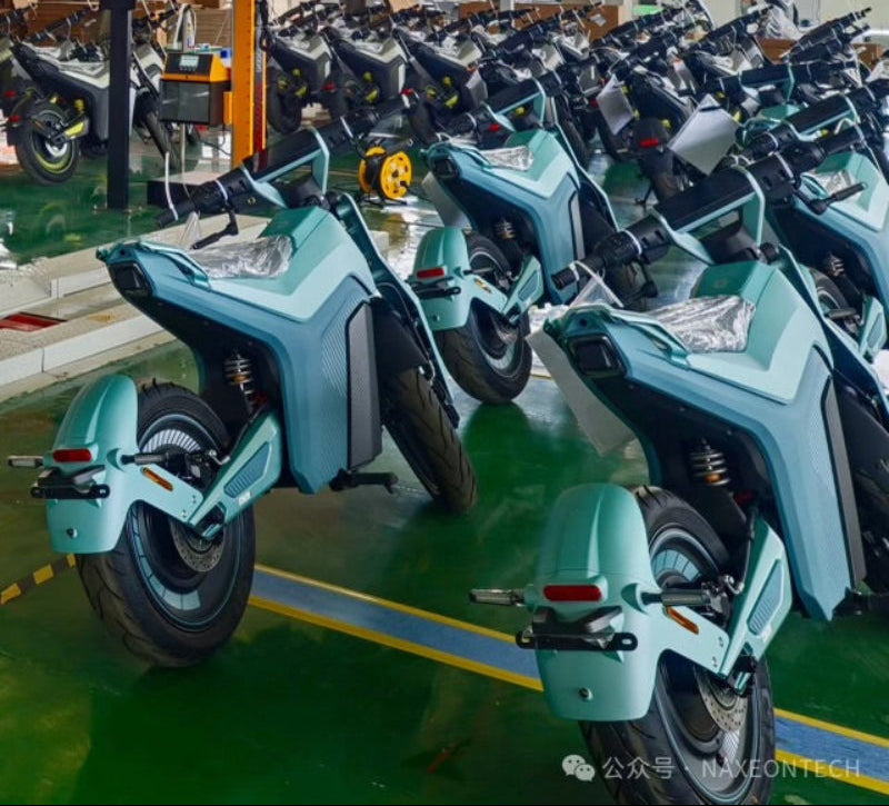 Indoor showroom with rows of Naxeon electric motorcycles in pastel blue, ready for sale at TurboPowersports