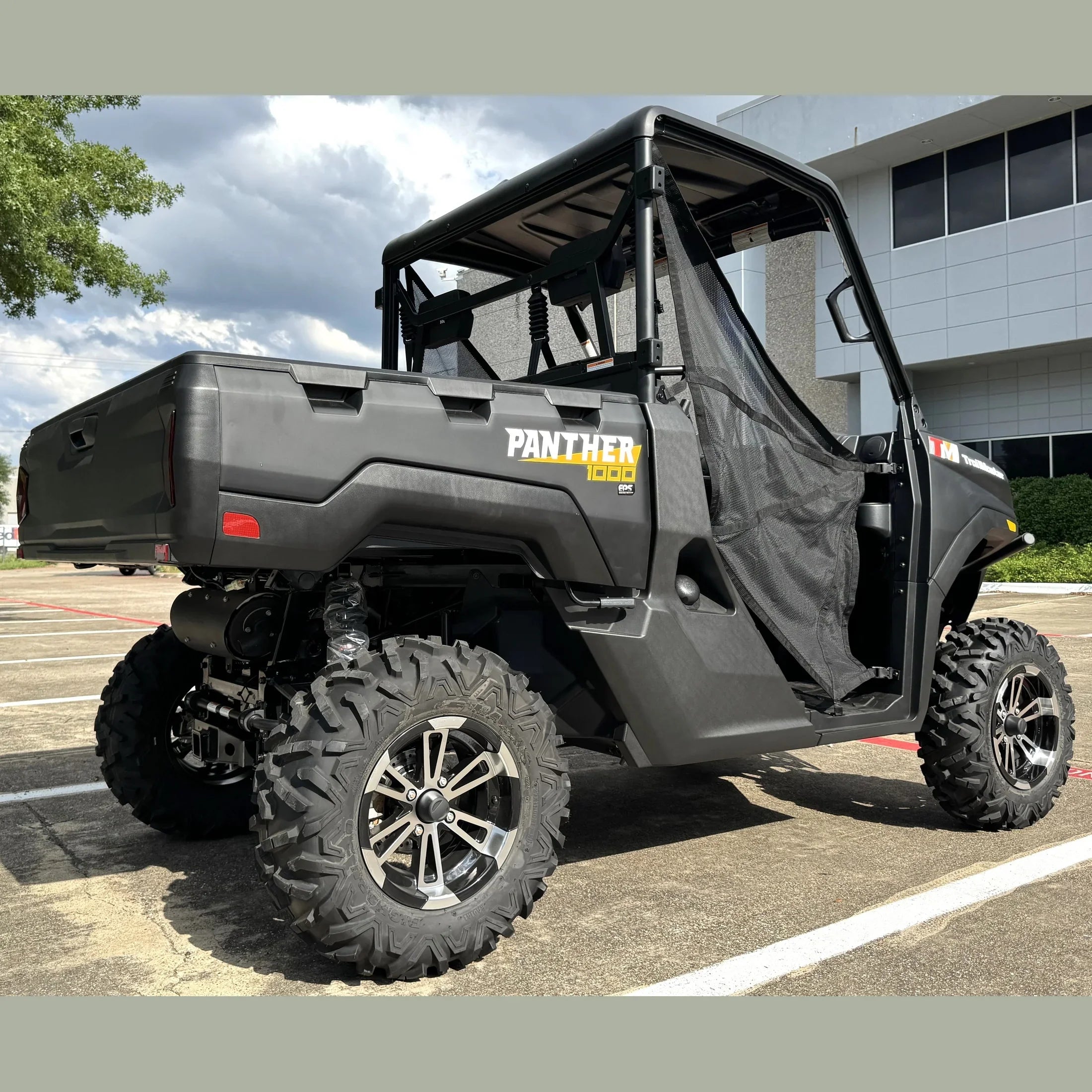Black Panther 1000 UTV with EPS, rugged tires, and mesh door, parked outdoors