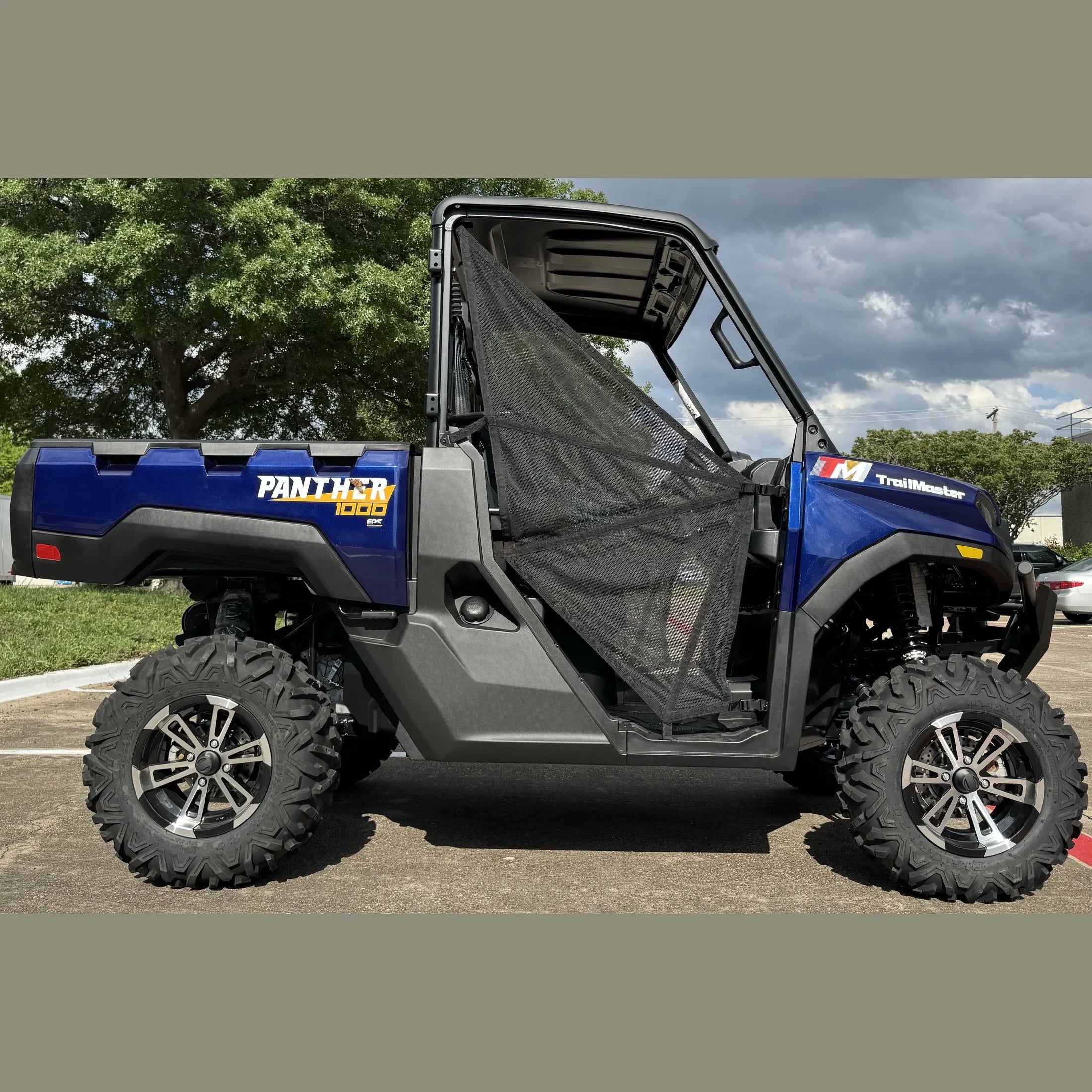 Blue TrailMaster Panther 1000 EPS UTV with mesh door, rugged tires, parked outdoors