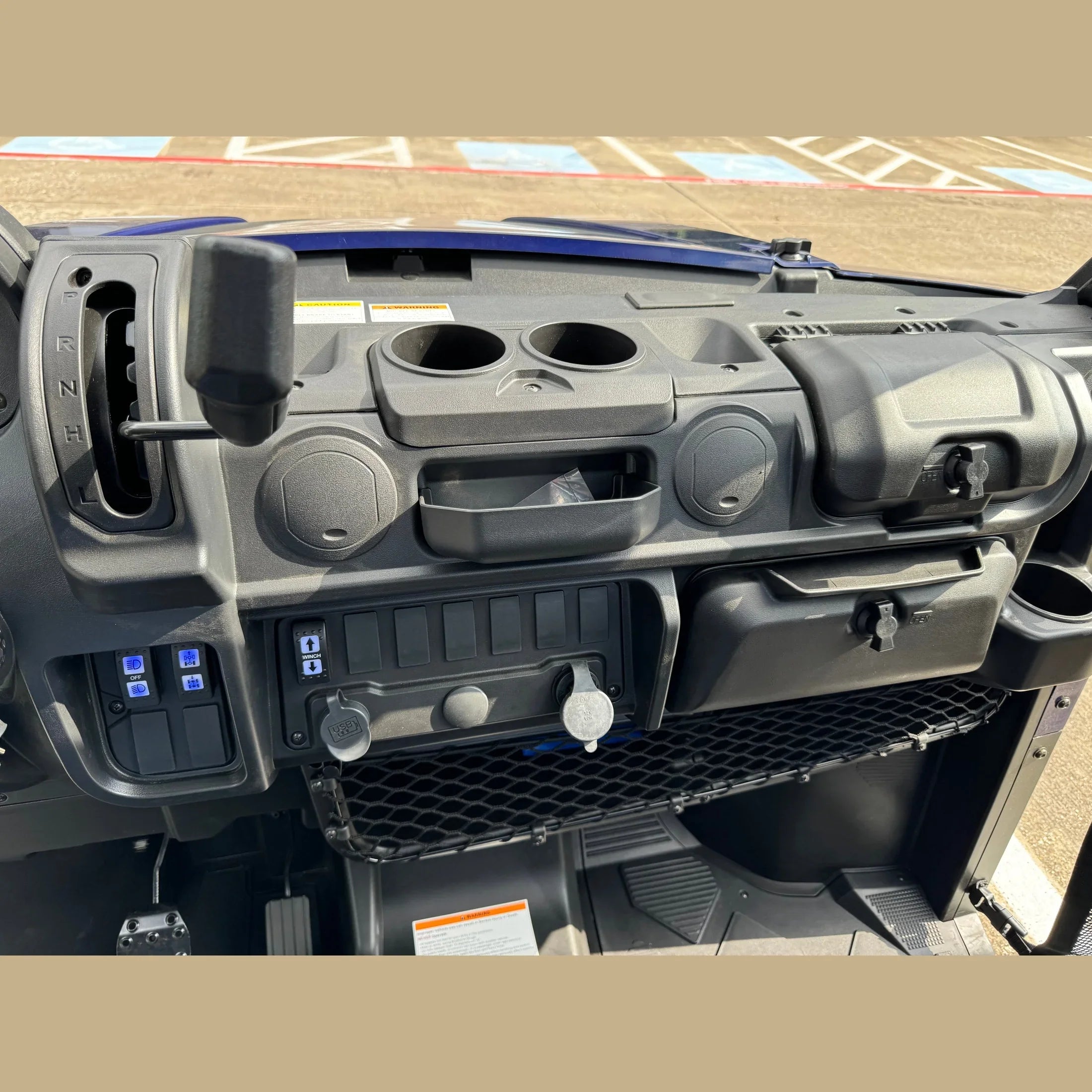 UTV dashboard with gear shifter, cup holders, USB ports, and control switches for off-road use