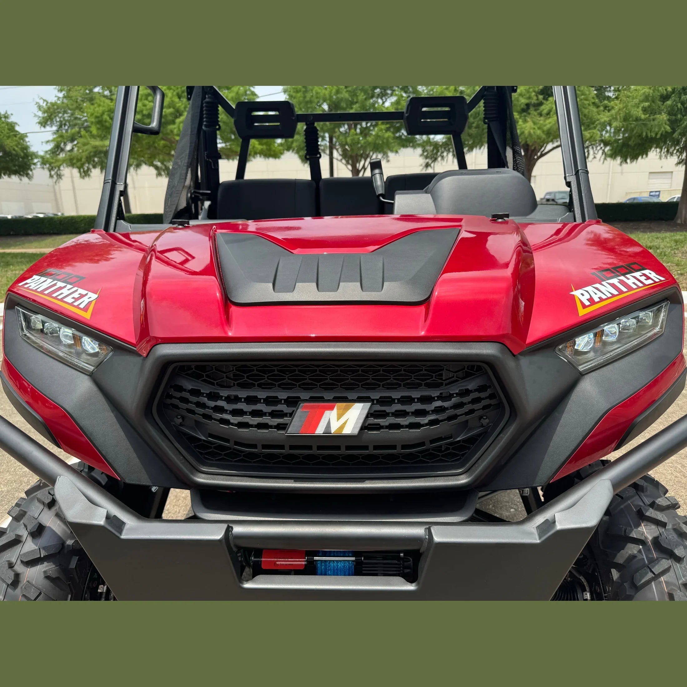 Red 1000 Panther UTV with TM grille, LED headlights, and front winch, parked outdoors
