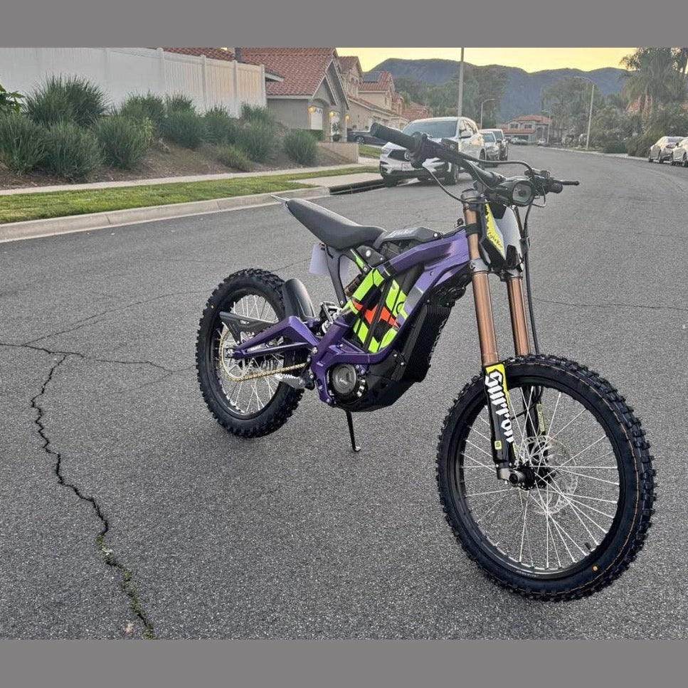 Purple Skytour electric dirt bike with green accents parked on residential street