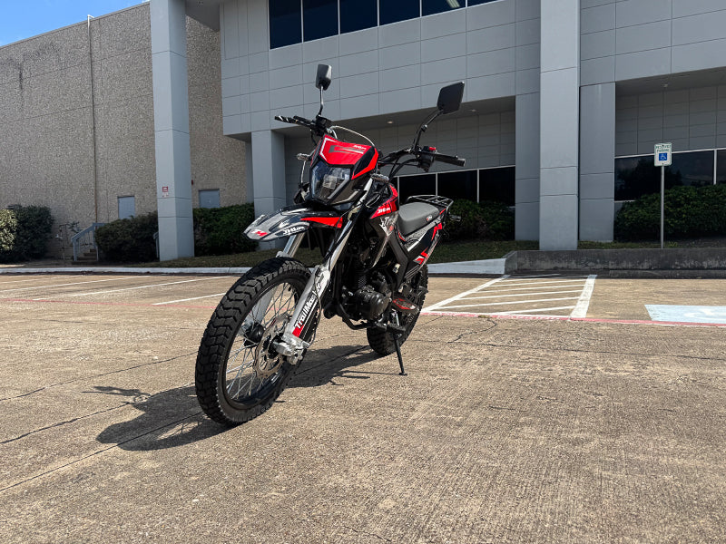 Front three-quarter view of red and black TrailMaster RMX250 with inverted forks