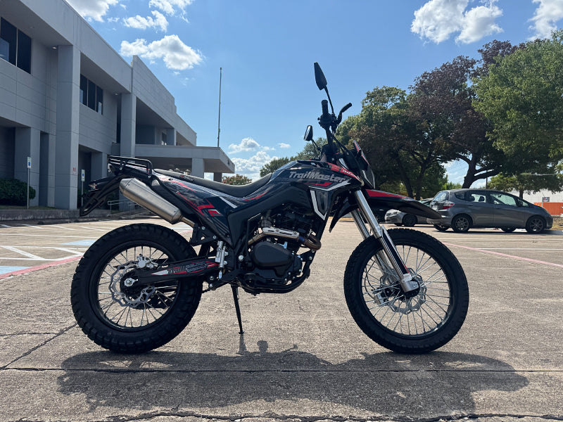 Outdoor shot of red and black TrailMaster RMX250 dual sport bike on asphalt